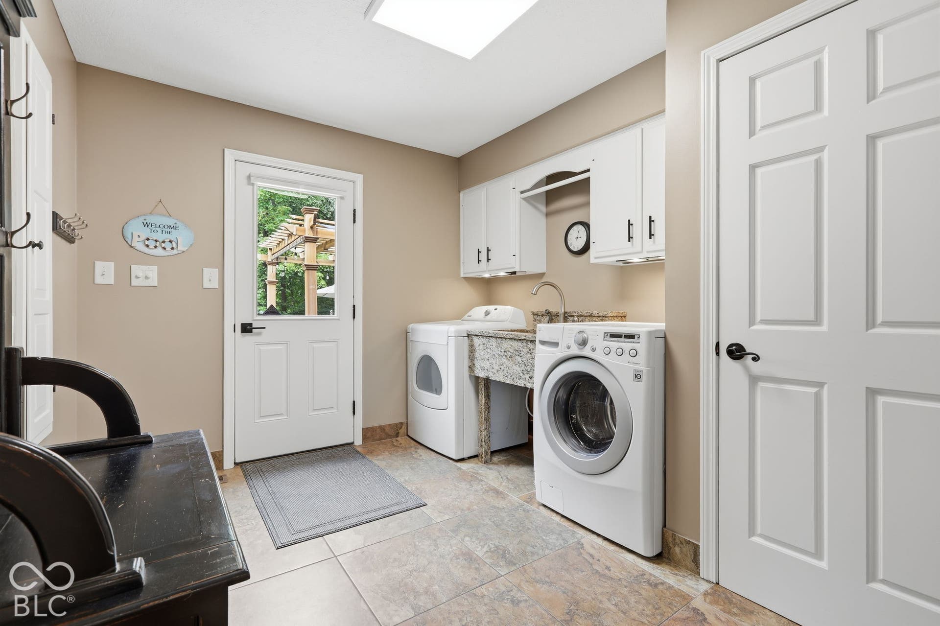 Bright Laundry with Skylight and Outdoor Access to Pool and Hot Tub Area