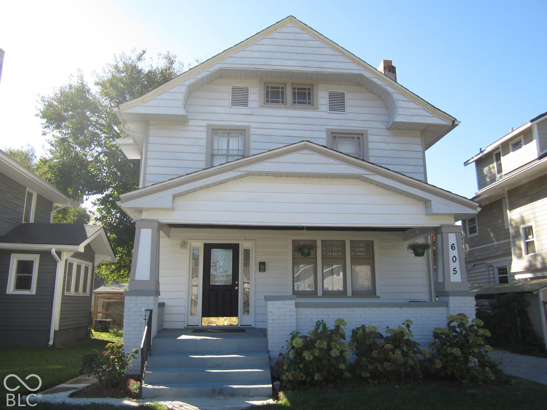 Craftsman-style exterior featuring horizontal lap siding, a covered front porch with tapered columns, a stone-base foundation, and multi-pane transom windows