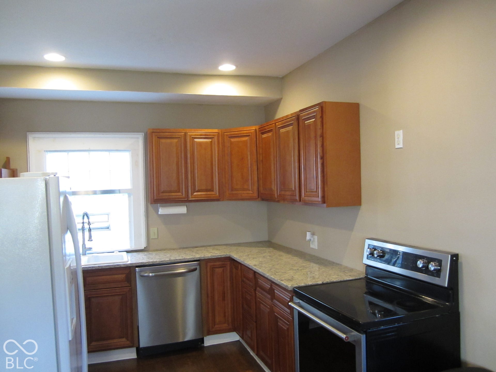 Kitchen featuring wood cabinetry, stone-finish countertops, stainless steel dishwasher, integrated range, and recessed ceiling lighting