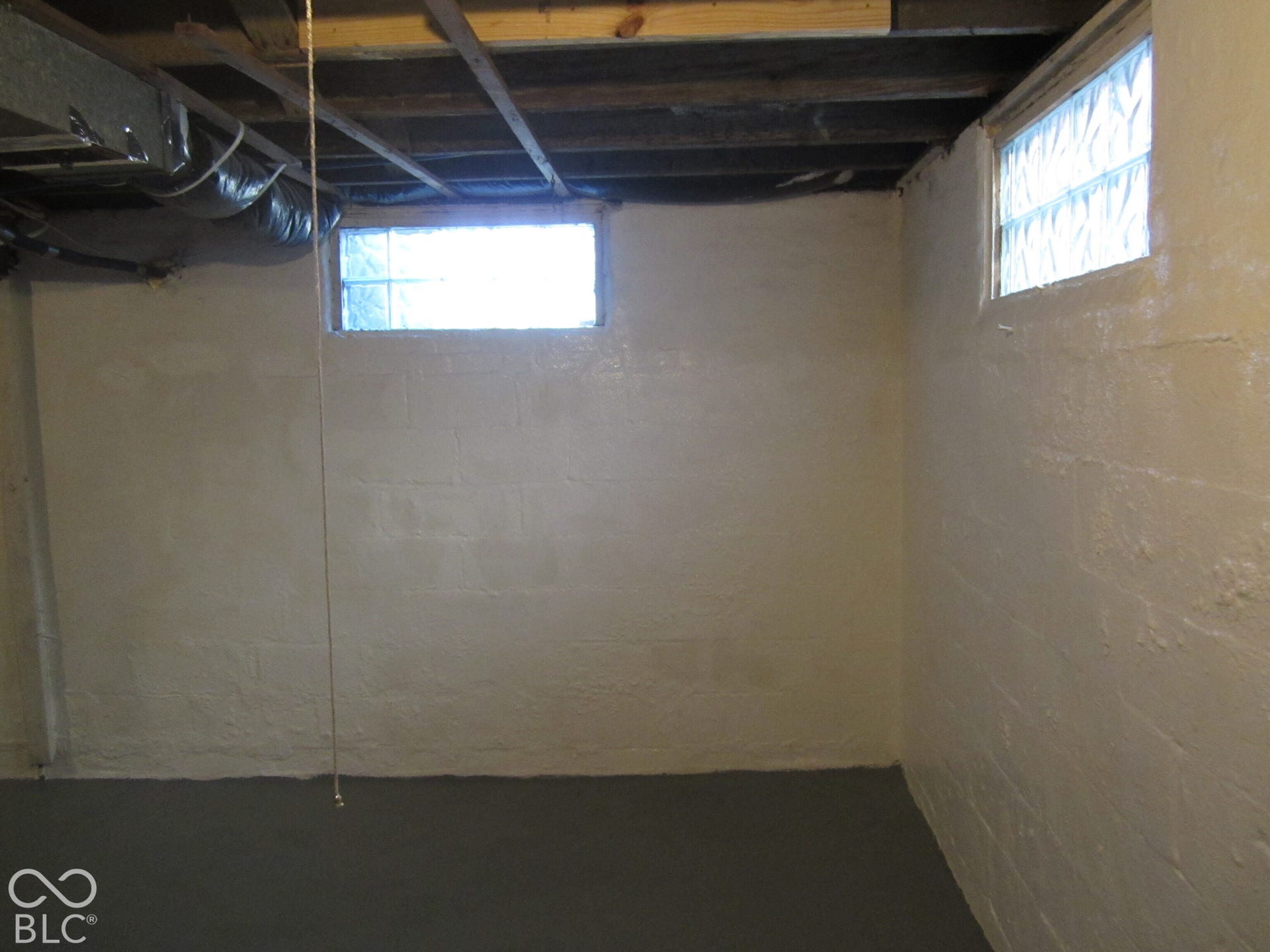 Painted concrete block foundation walls, painted concrete flooring, and glass block windows