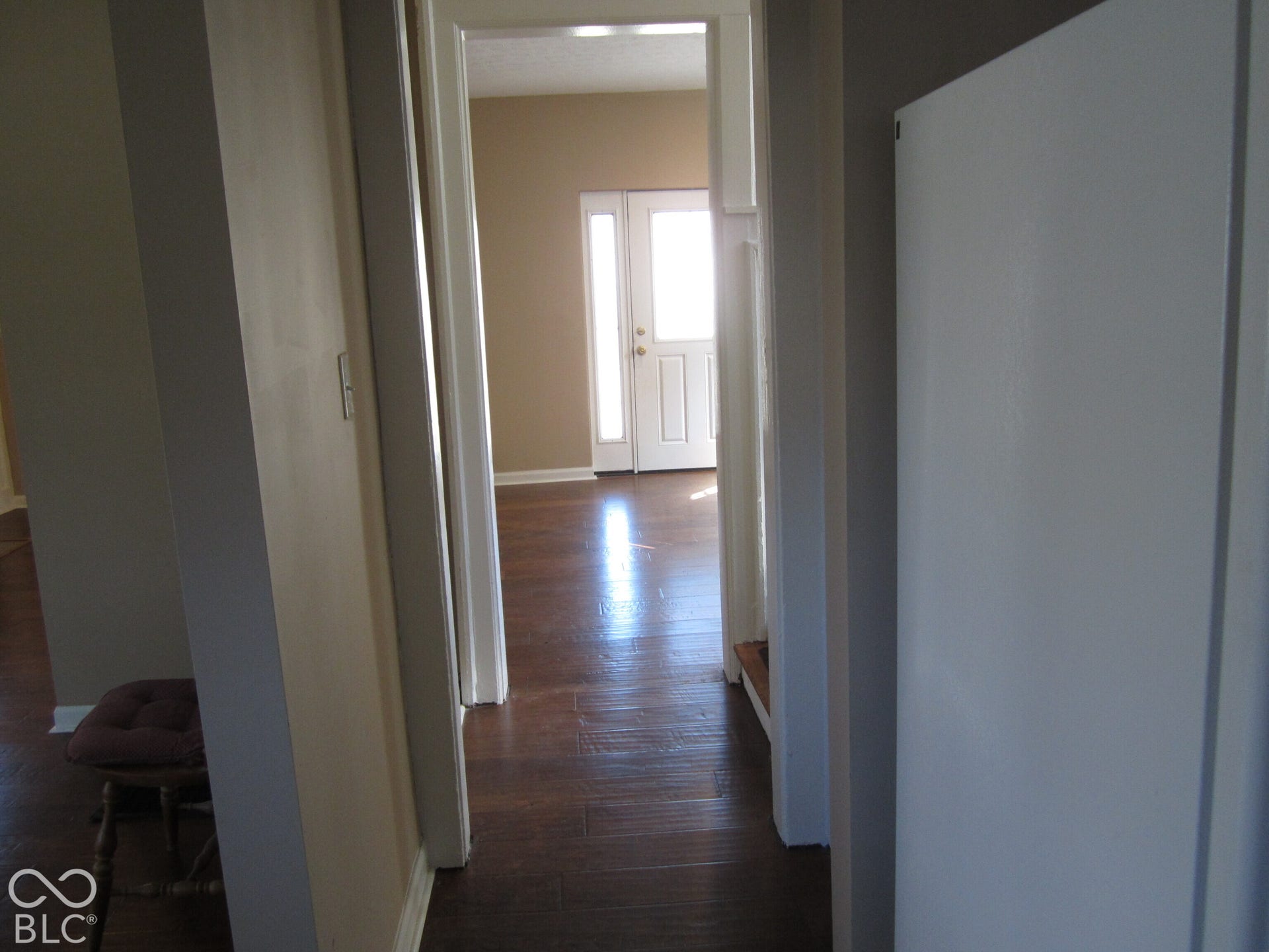Wood-finish flooring, white door casing, and an exterior entry door with glass paneling