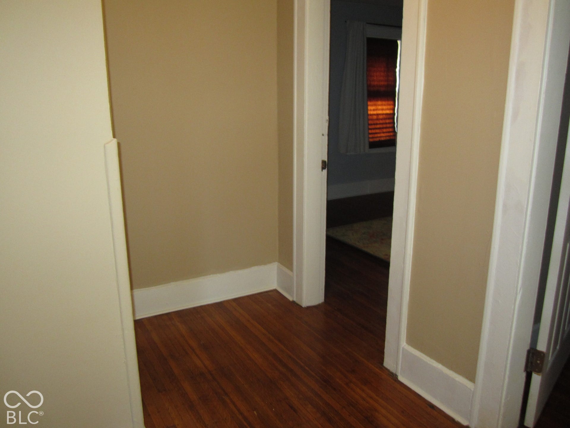 Interior space featuring wood-finish flooring and white painted door casings