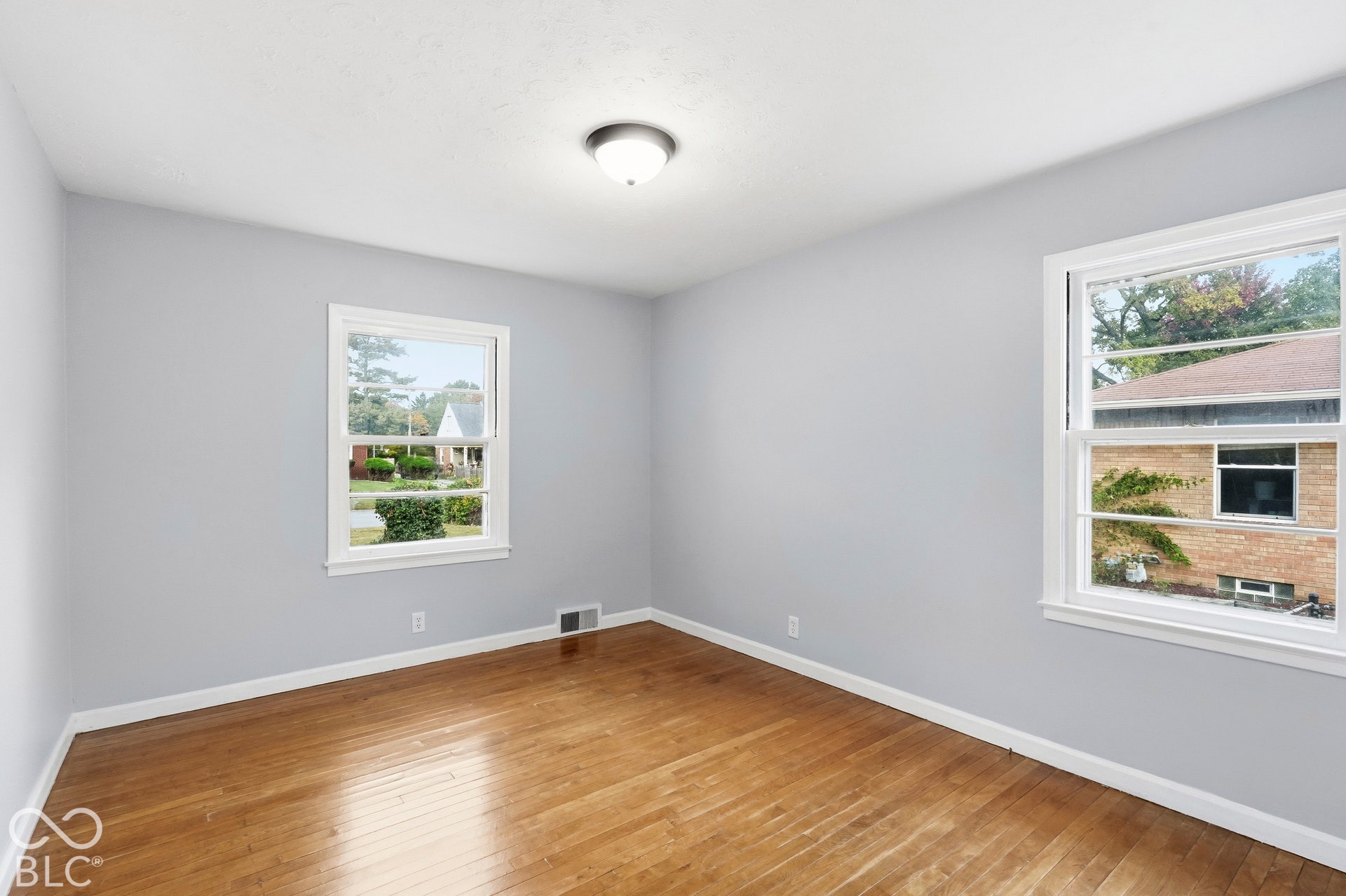 Neutral-toned walls, wood-finish flooring, and dual double-hung windows