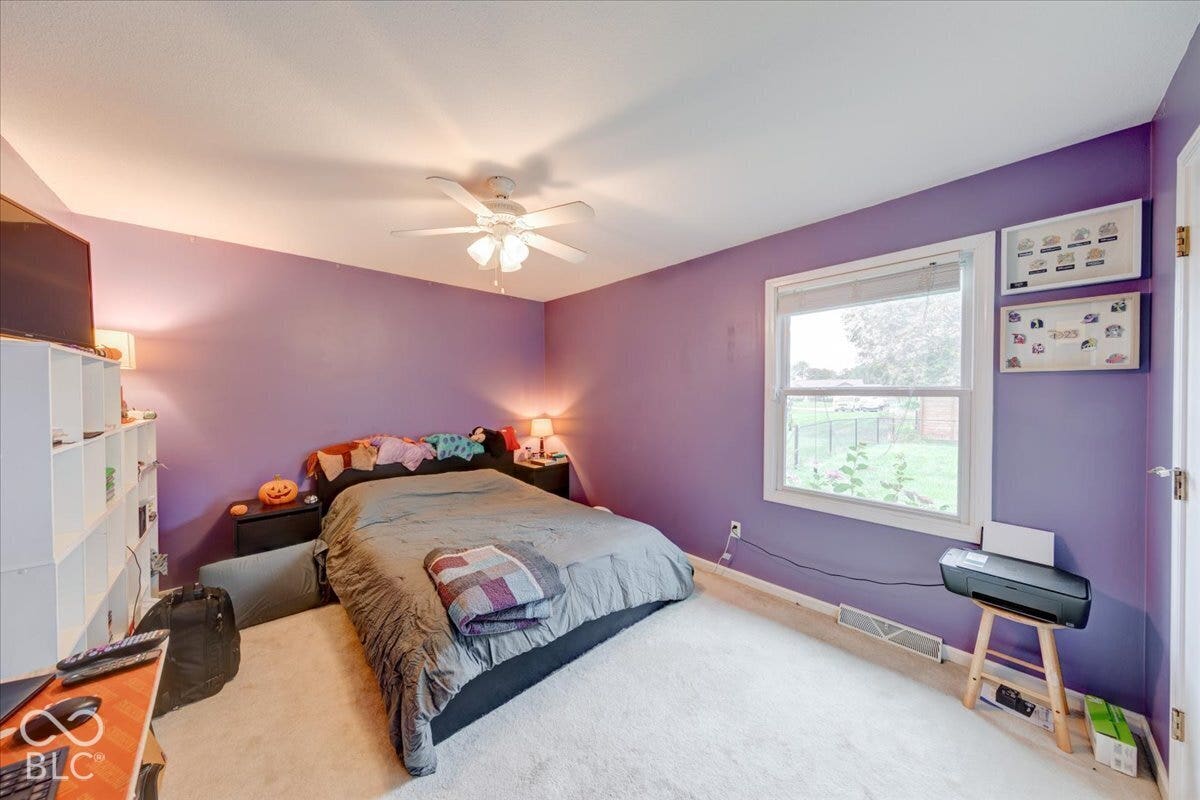 Room featuring wall-to-wall carpeting, a multi-blade ceiling fan with integrated lighting, and a window with exterior exposure