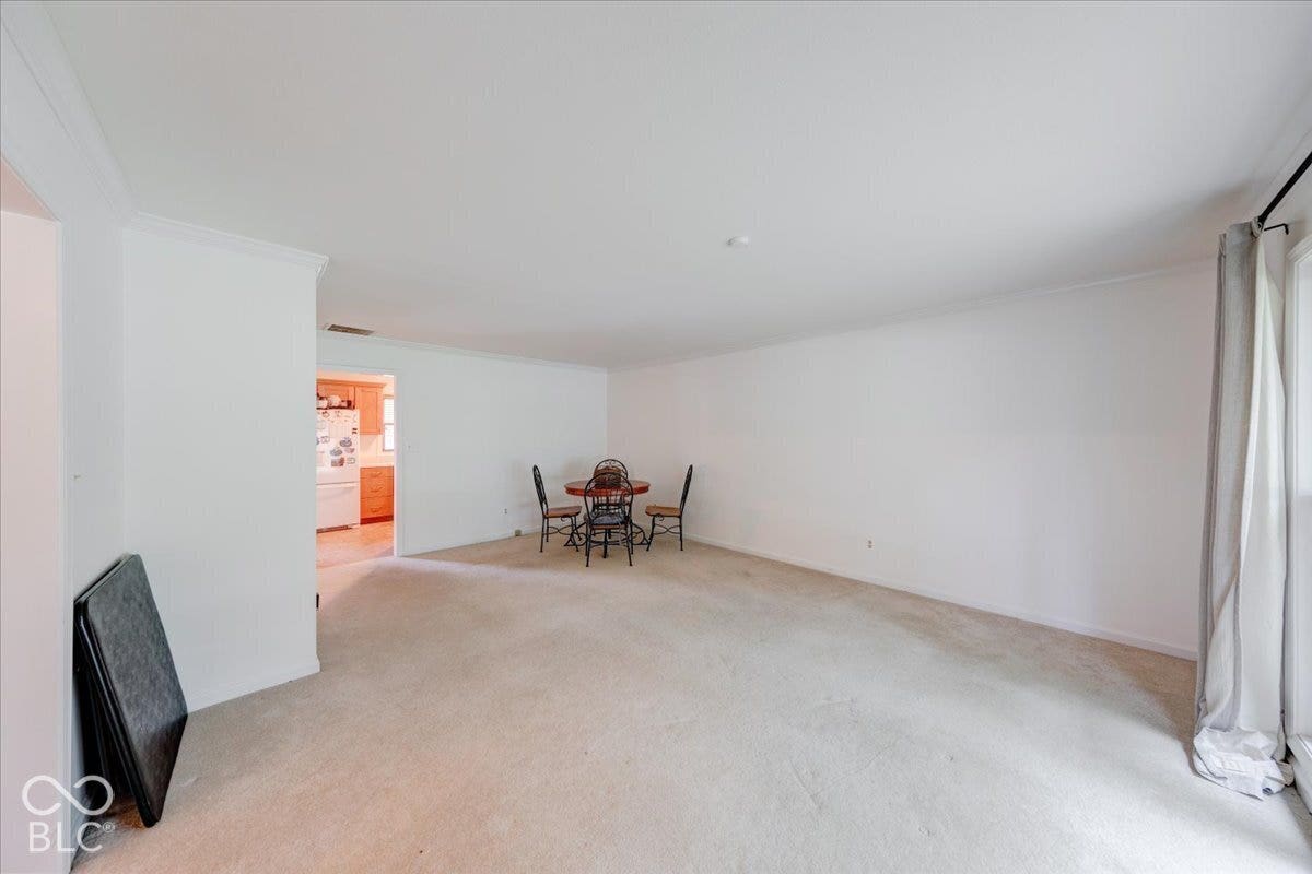 Neutral wall color, wall-to-wall carpeting, and crown molding