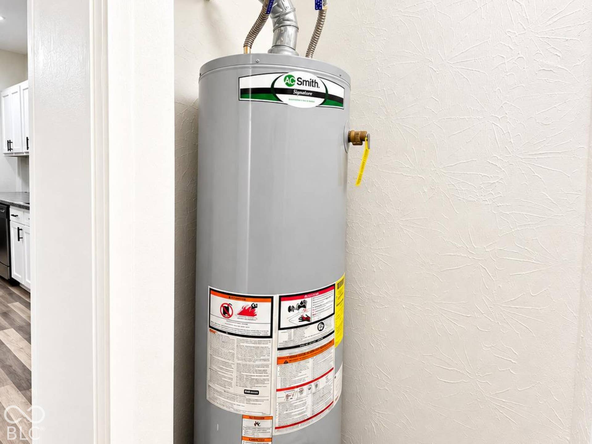 Gas-powered tank water heater with metal vent piping and rigid plumbing connections