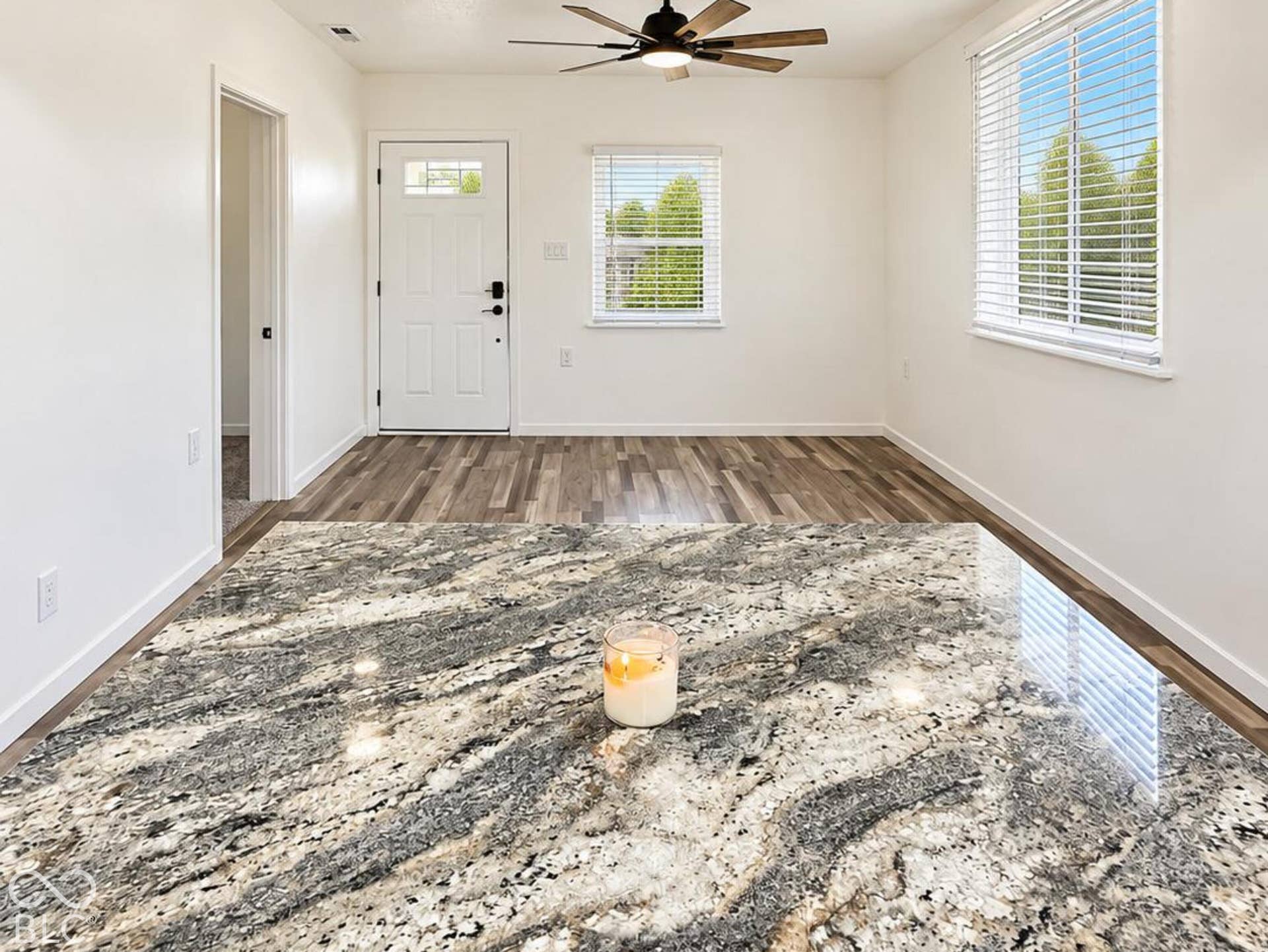 Interior space featuring wood-finish flooring, recessed lighting, a multi-blade ceiling fan, and windows equipped with horizontal blinds