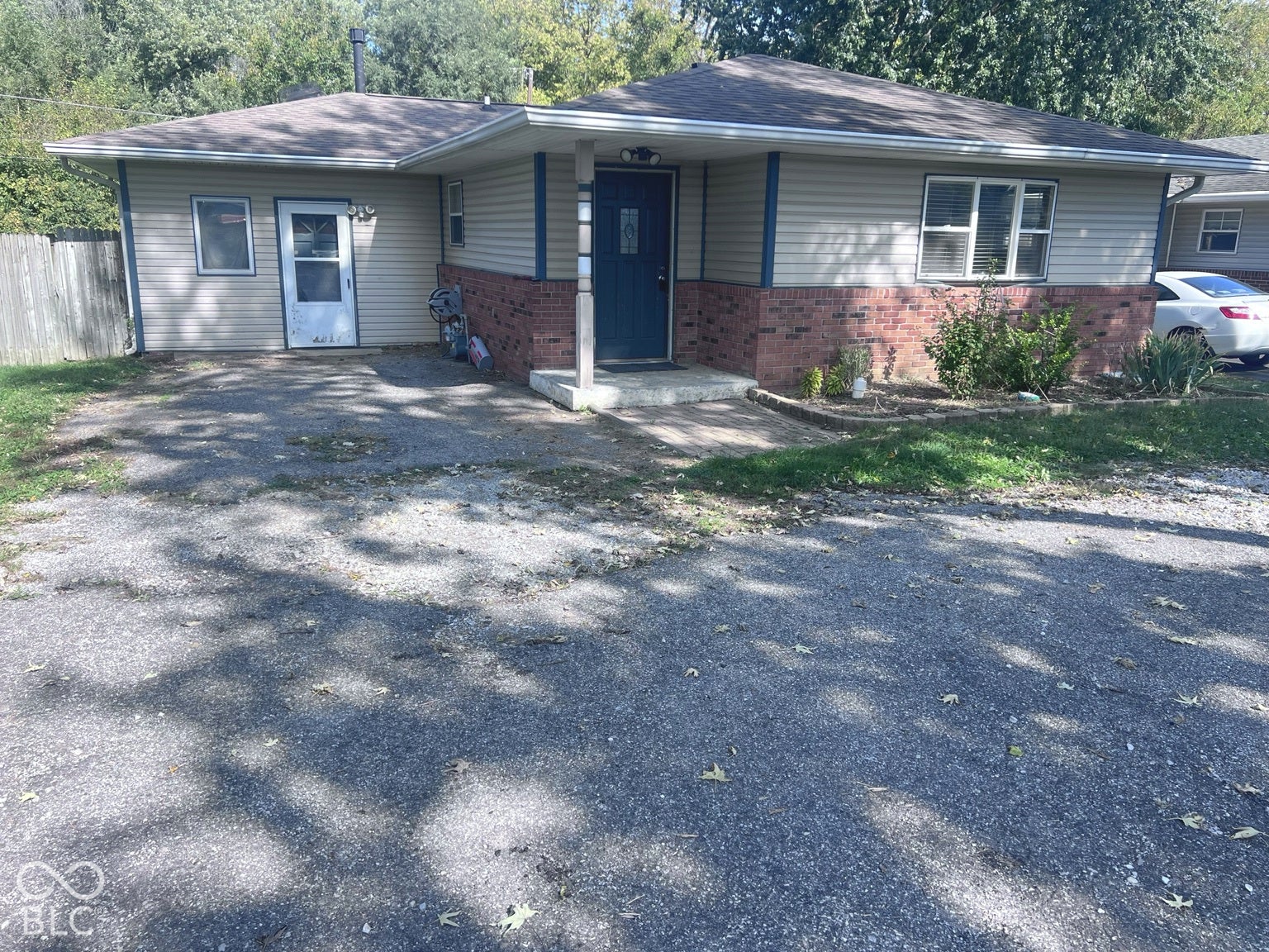 4906 W Troy Avenue, Indianapolis, IN 46241 Ranch-style exterior featuring horizontal vinyl siding, a red brick veneer lower facade, an asphalt roof, and a covered entry