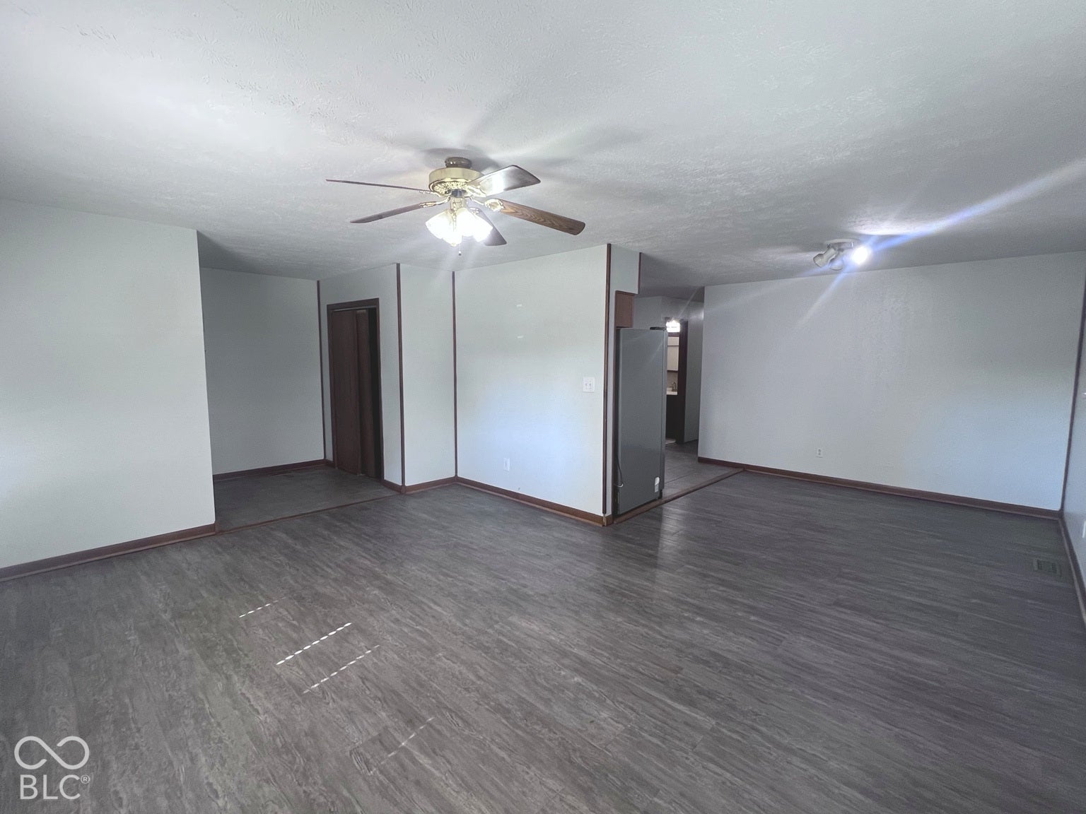 4906 W Troy Avenue, Indianapolis, IN 46241 Interior space featuring wood-finish flooring, neutral wall tones, and a ceiling-mounted light fixture with a multi-blade fan