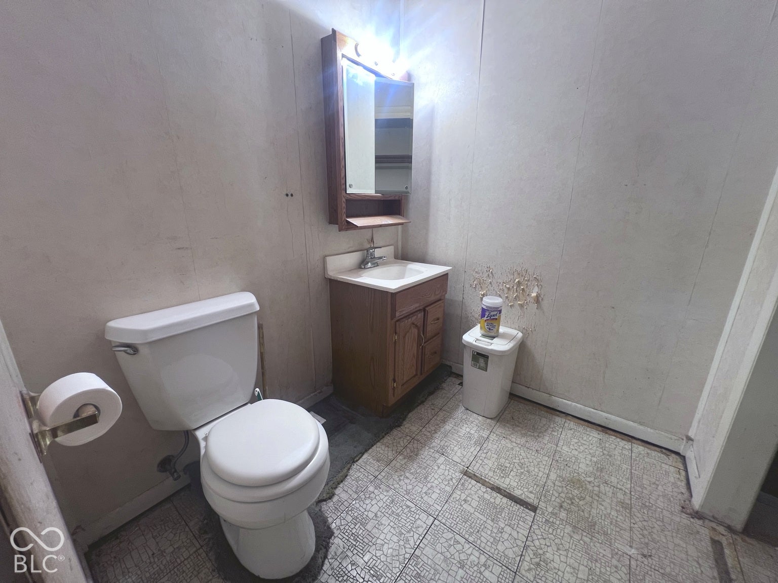 4906 W Troy Avenue, Indianapolis, IN 46241 Bathroom featuring a wood-finish vanity, integrated sink, mirrored medicine cabinet with built-in lighting, and tiled flooring