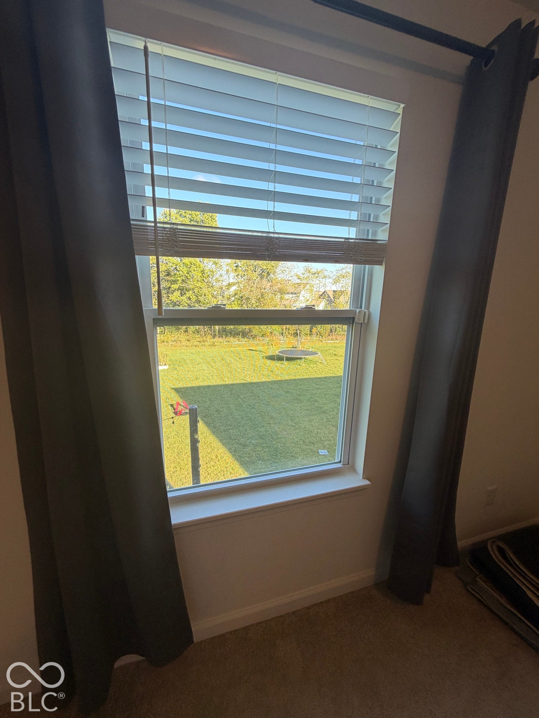 Single-hung window featuring horizontal blinds and a sill