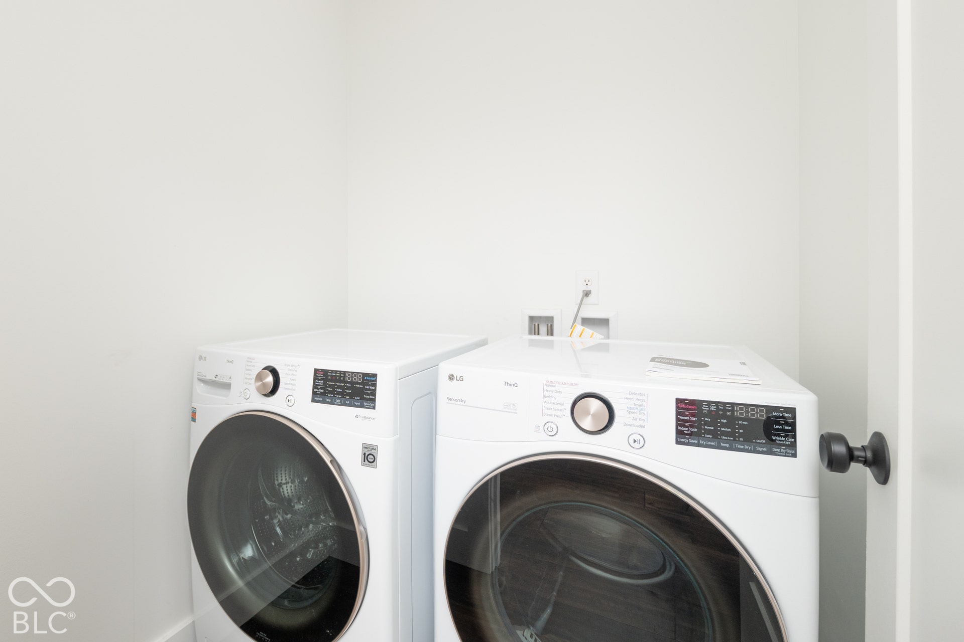 1401 Olive Street, Indianapolis, IN 46203 Laundry space featuring front-load washing machine and dryer units with digital control panels and metallic finish hardware