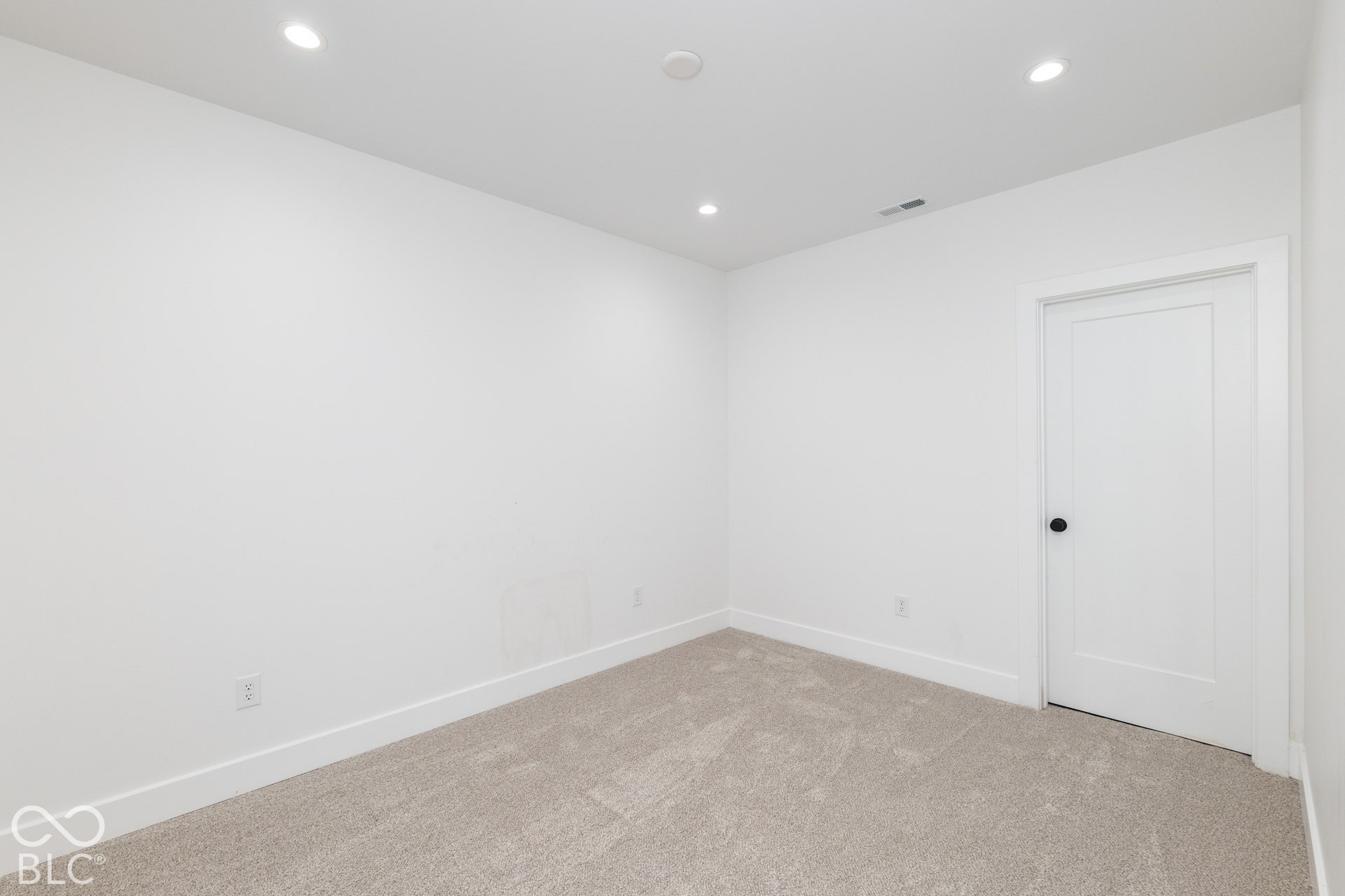 1401 Olive Street, Indianapolis, IN 46203 Neutral-toned room featuring plush wall-to-wall carpeting, recessed ceiling lighting, and a solid-core door with matte black hardware