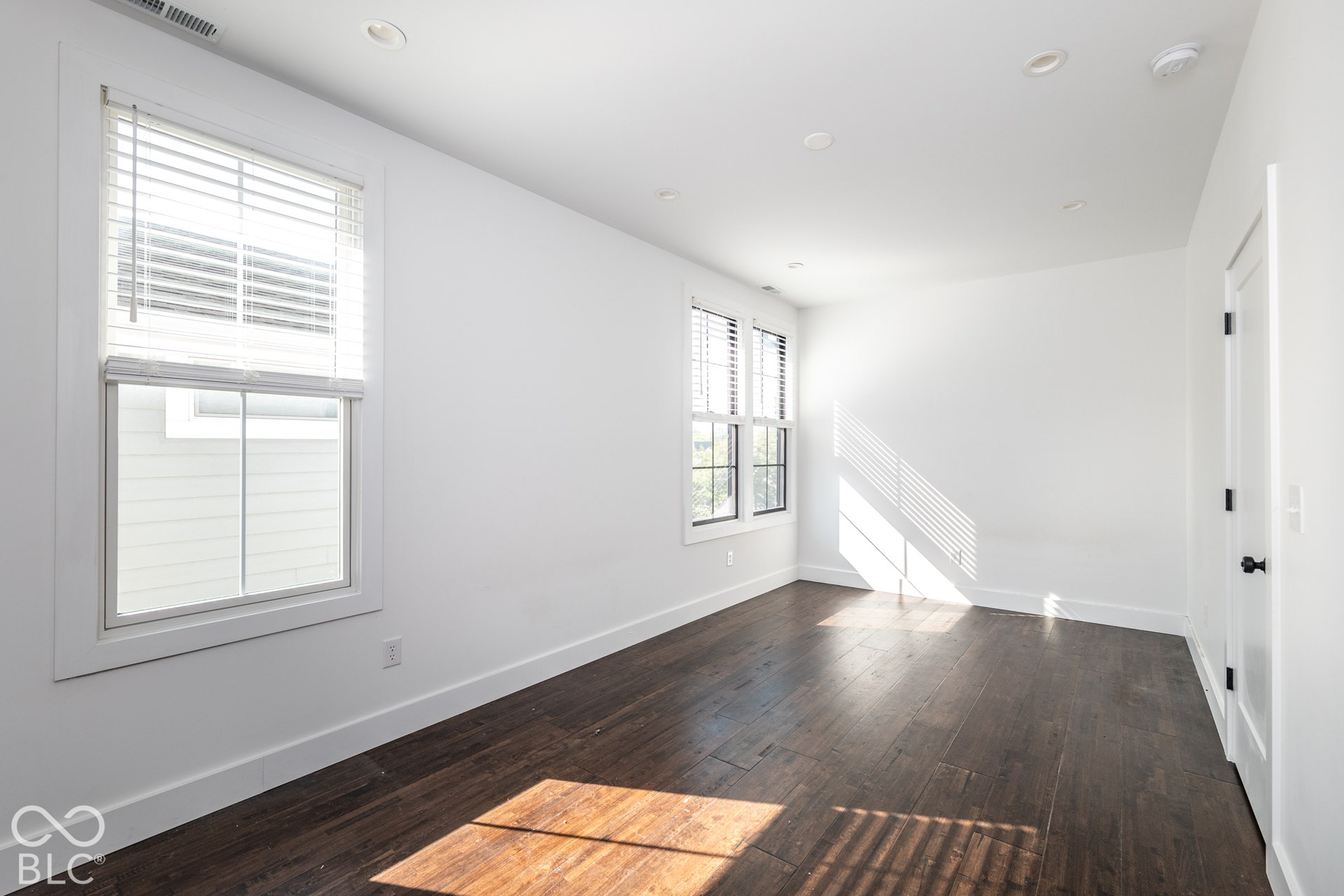 1401 Olive Street, Indianapolis, IN 46203 Interior space featuring wood-finish flooring, recessed lighting, multi-pane windows with integrated blinds, and solid-core interior doors with matte black hardware