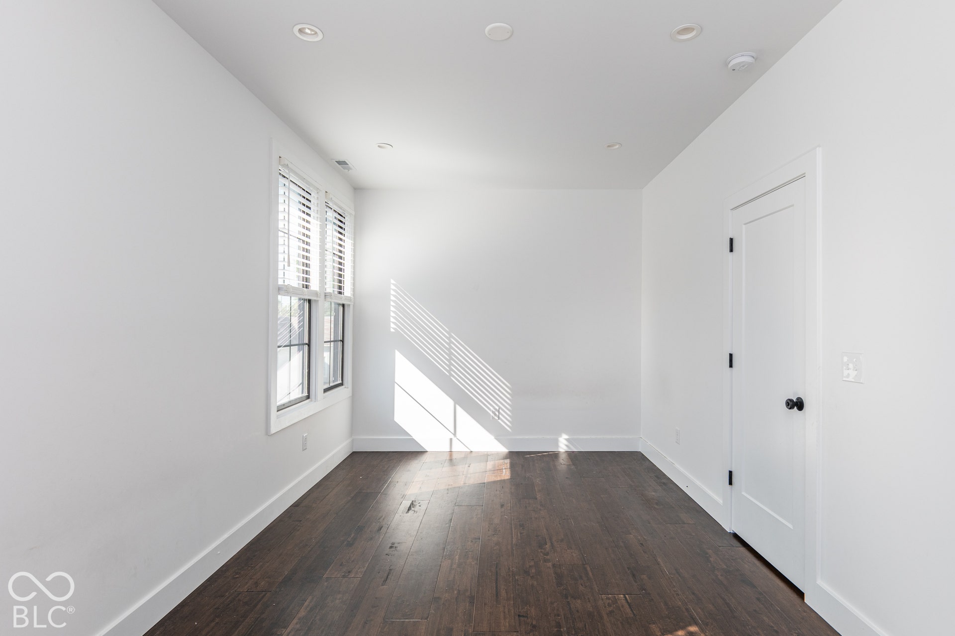 1401 Olive Street, Indianapolis, IN 46203 Interior space featuring wood-finish flooring, recessed lighting, white walls, double-pane windows, and a single-panel interior door with matte black hardware