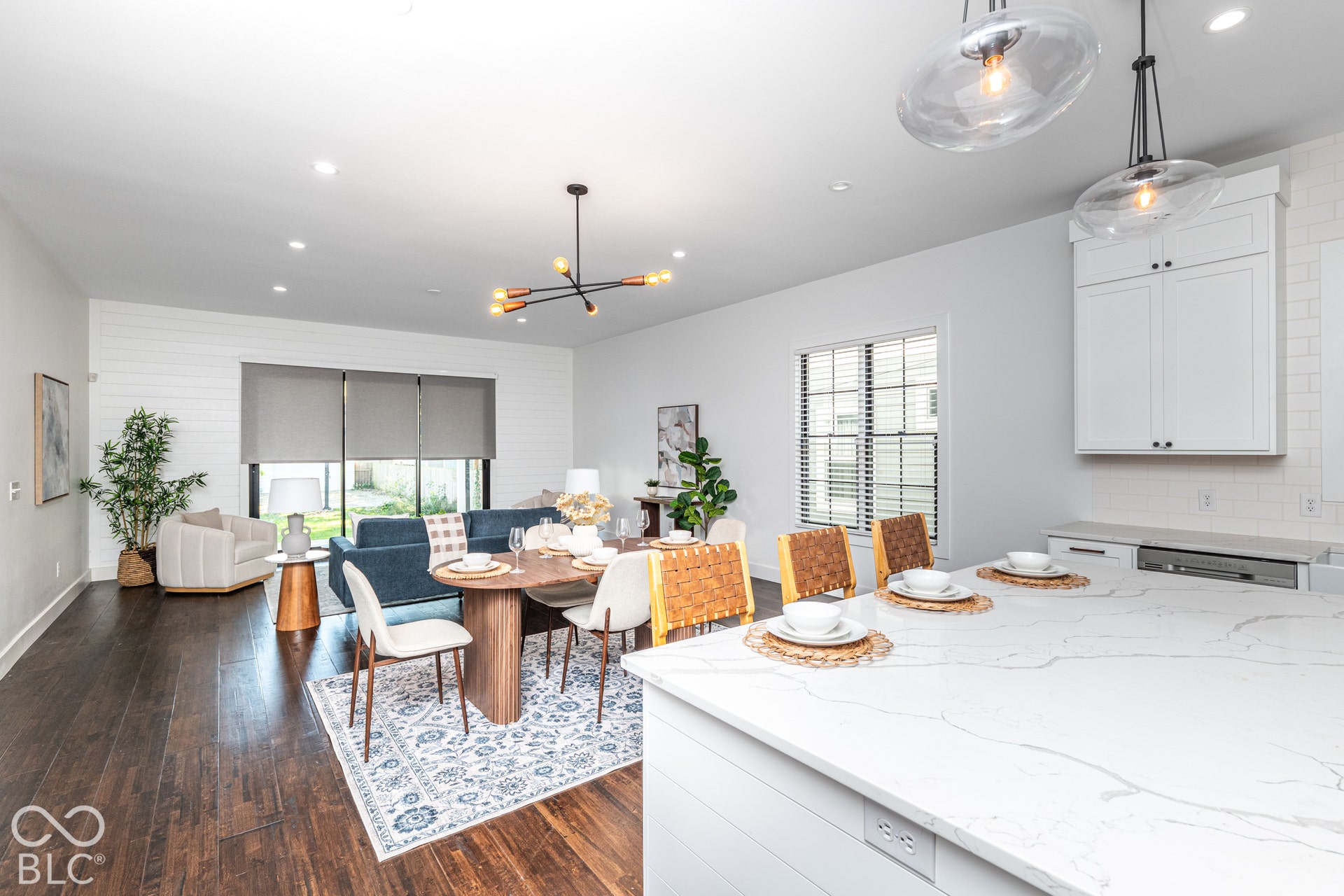 1401 Olive Street, Indianapolis, IN 46203 Open-concept kitchen featuring an oversized island with a stone-surface countertop, white cabinetry, wood-finish flooring, recessed lighting, and contemporary pendant fixtures