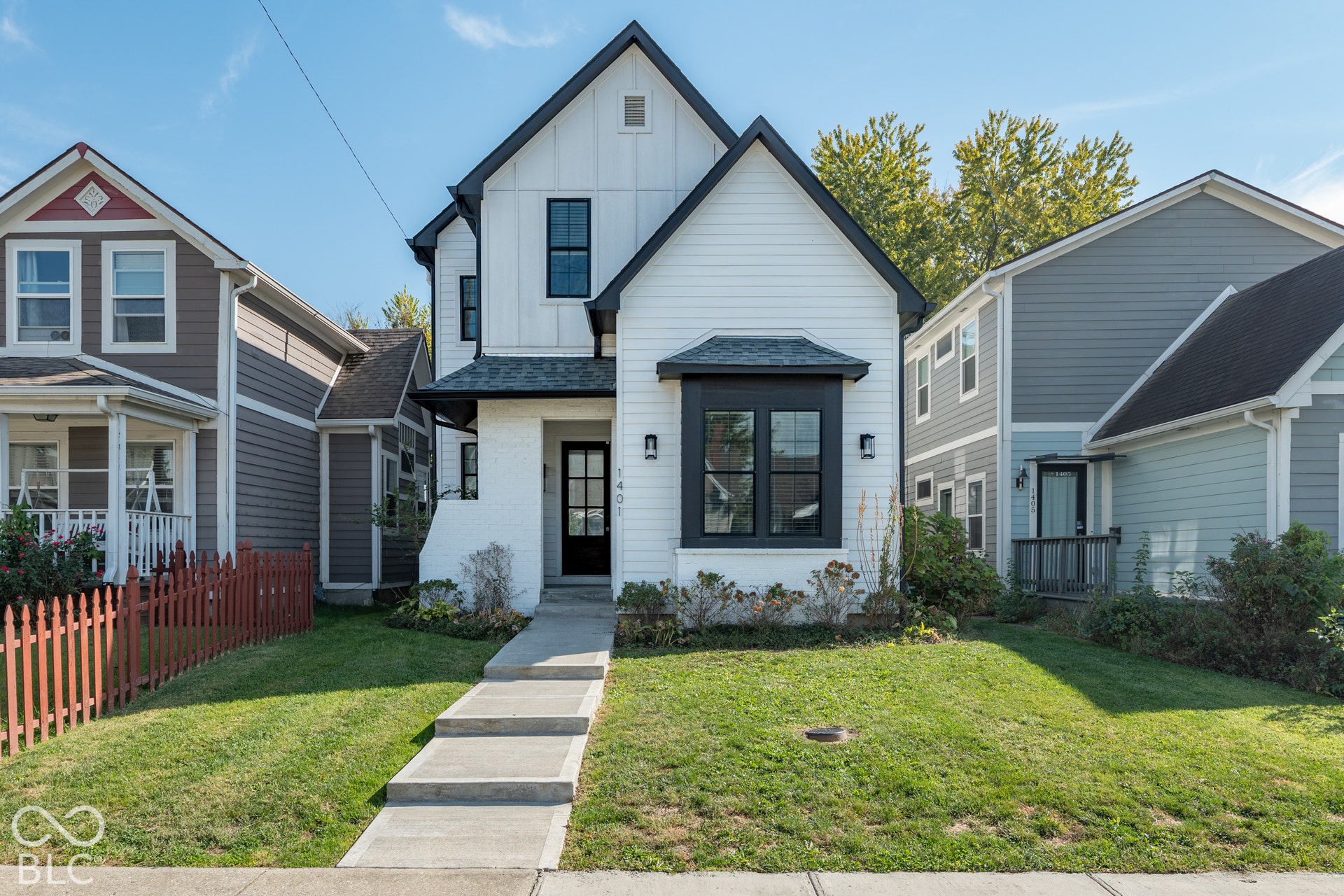 1401 Olive Street, Indianapolis, IN 46203 Modern farmhouse exterior featuring vertical board-and-batten siding, a covered front entryway, painted brick facade accents, and contrasting dark-framed multi-pane windows