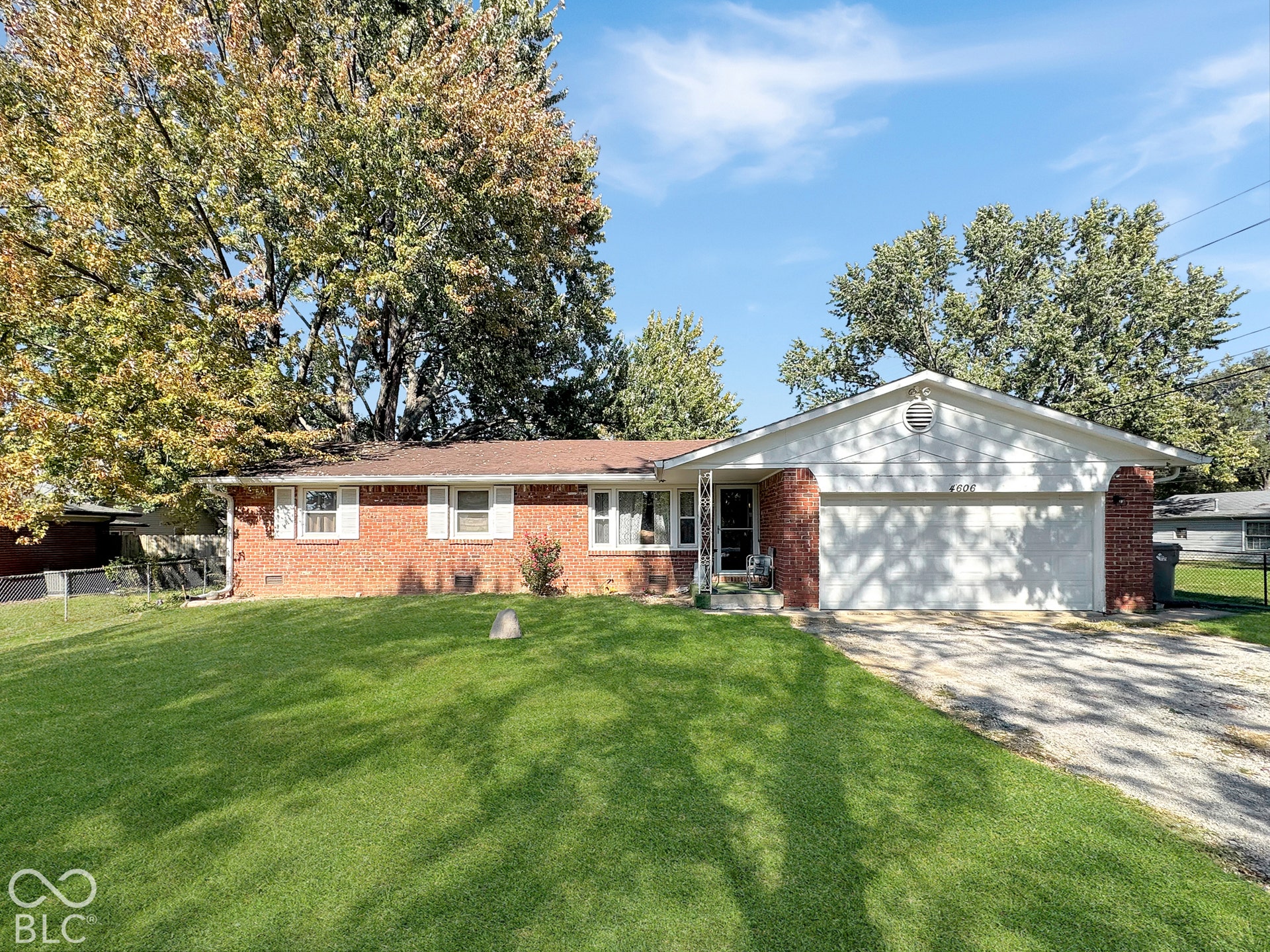 Virtually Altered - Single-story brick exterior featuring a multi-gable roofline, attached two-car garage, and mature trees