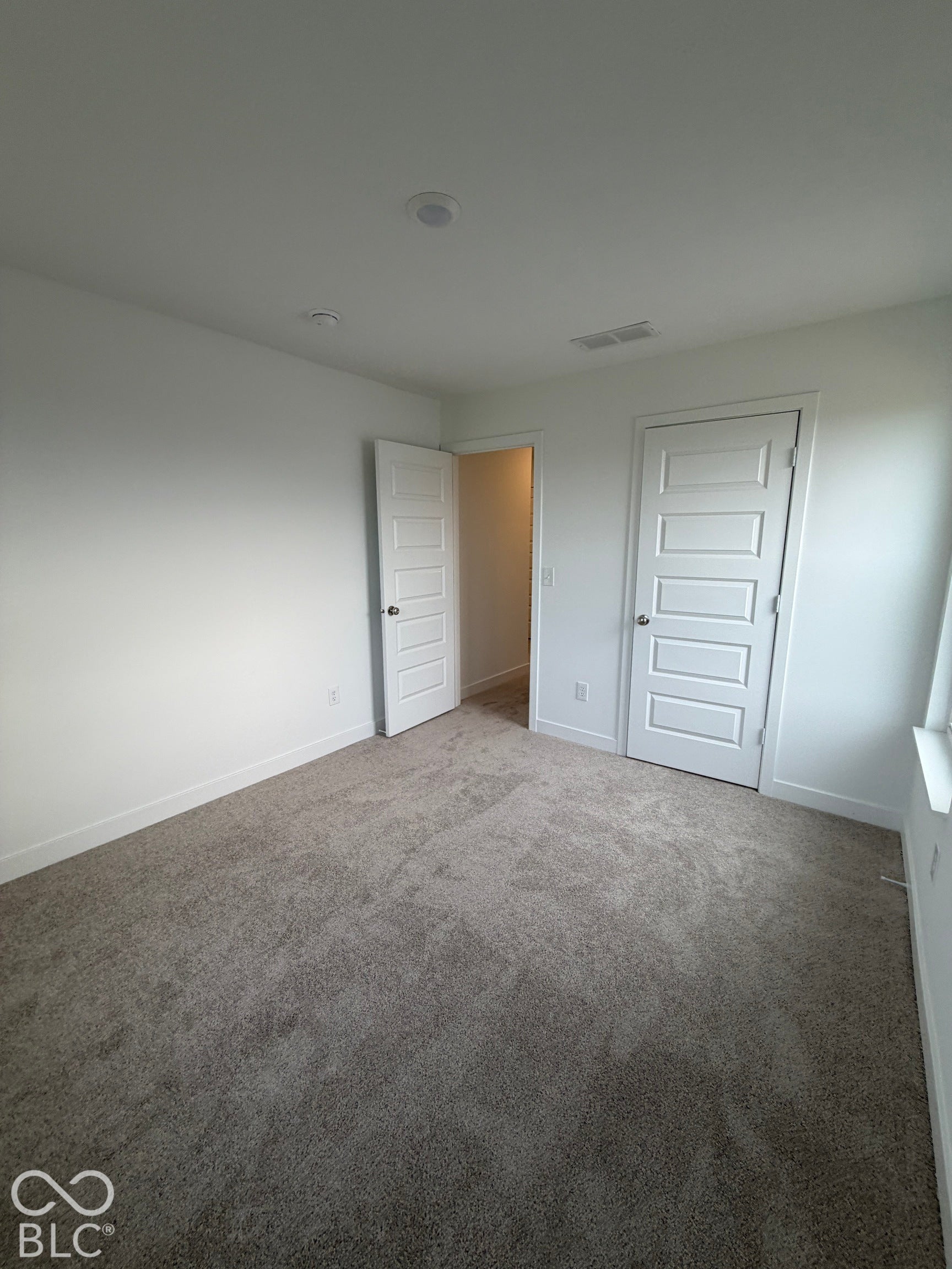Neutral-toned carpeting, five-panel interior doors, and recessed ceiling lighting
