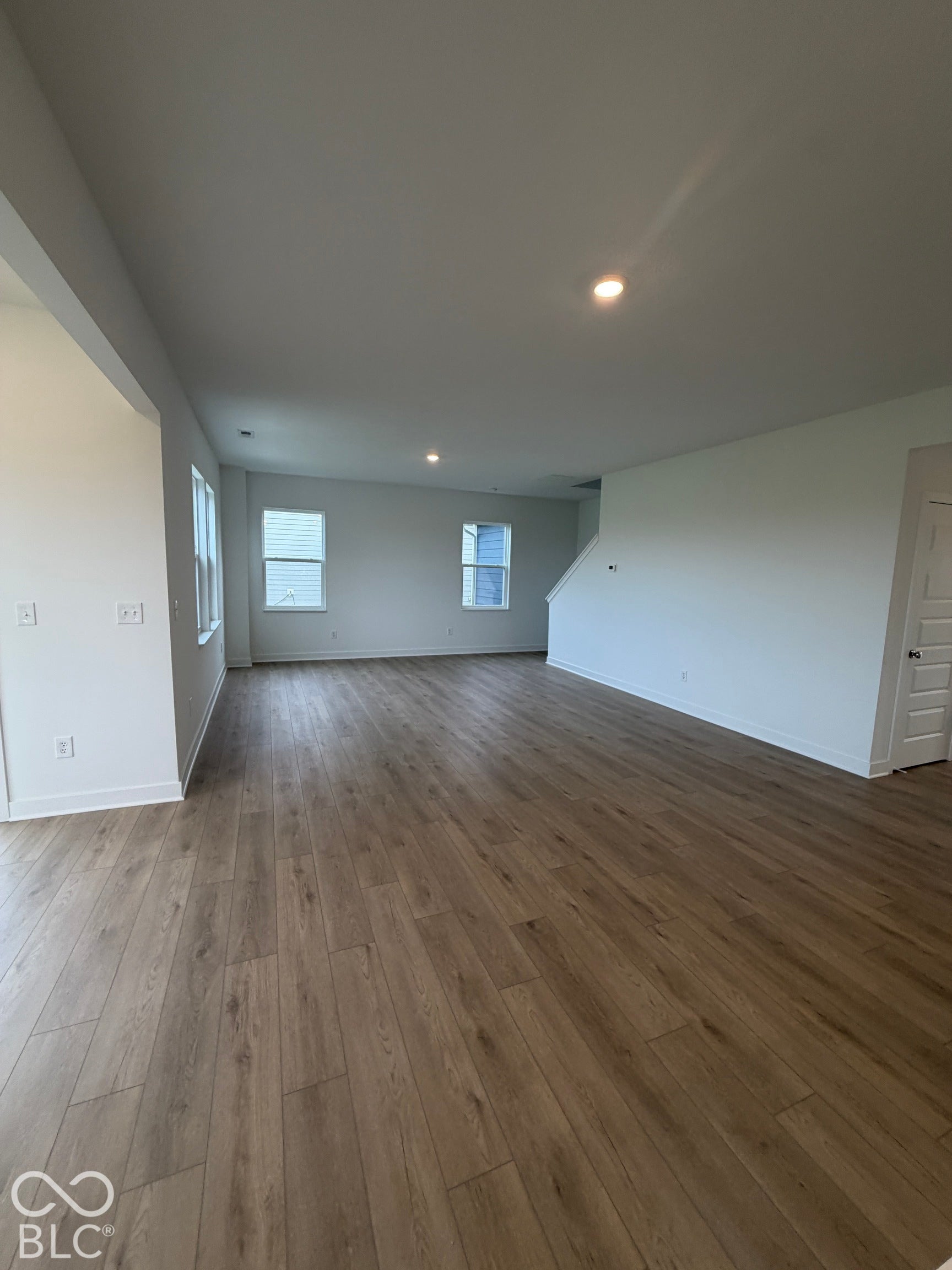 Open-concept interior featuring wood-finish flooring, recessed lighting, and multiple windows