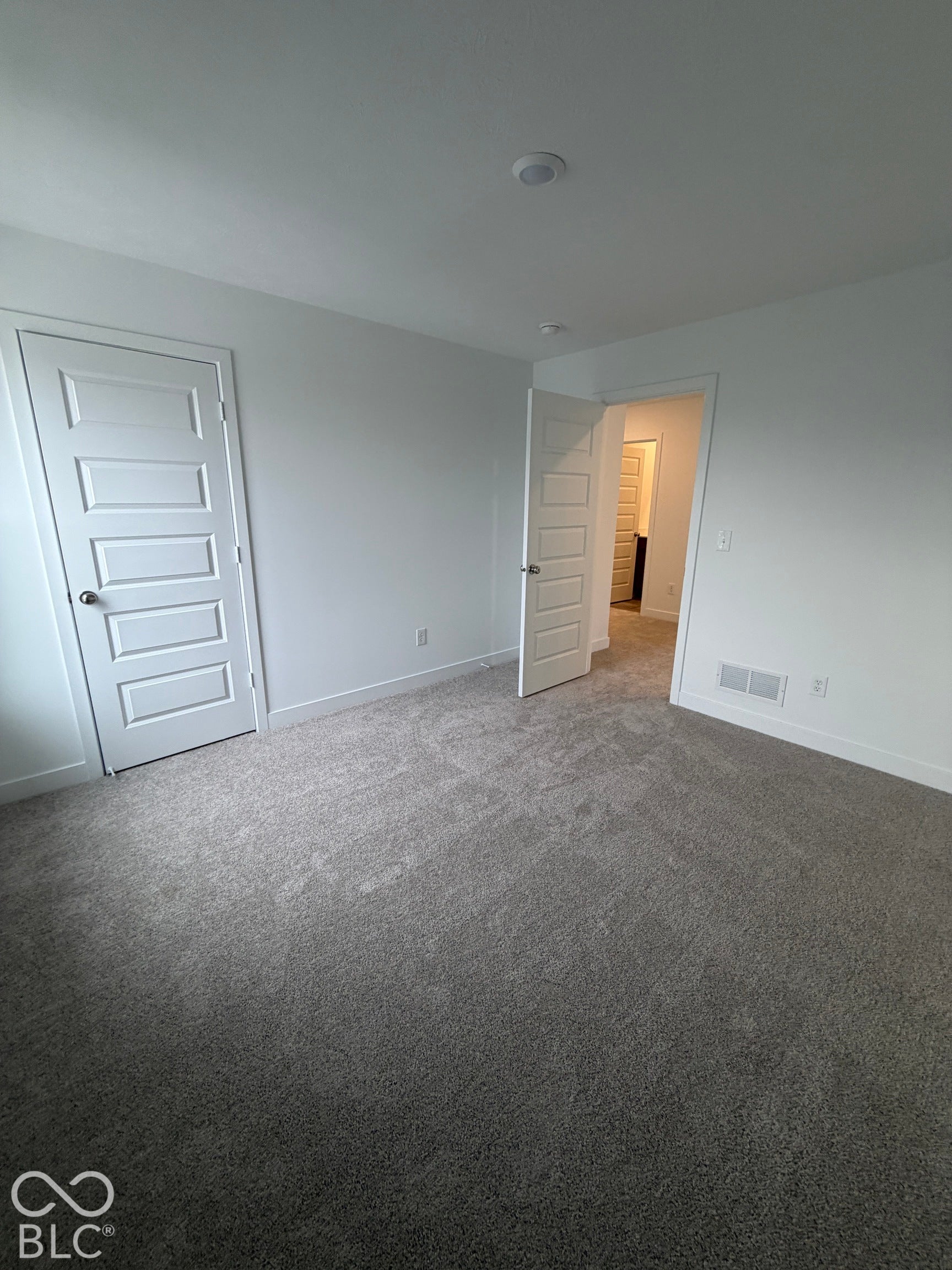 Neutral-toned wall-to-wall carpeting, white four-panel interior doors, and recessed ceiling lighting