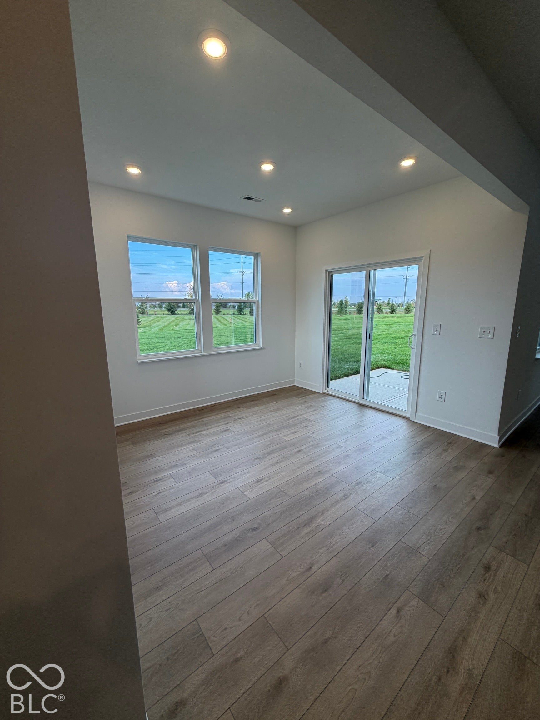 Wood-finish flooring, recessed lighting, double-pane windows, and sliding glass door with access to exterior concrete patio