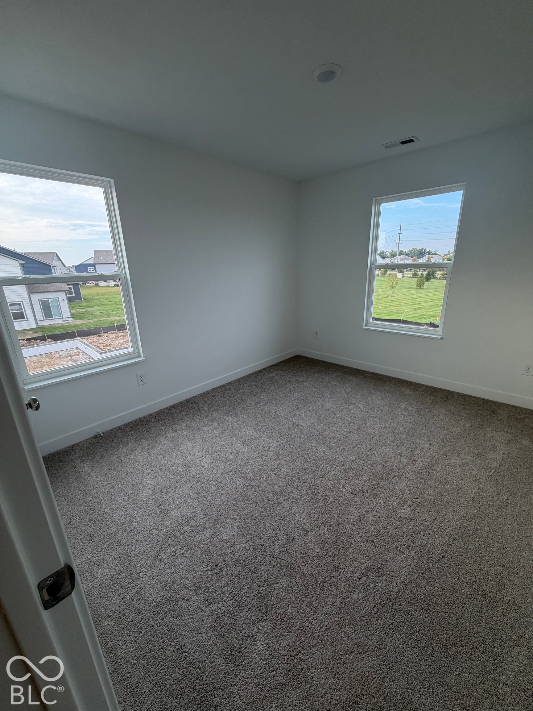 Neutral-toned carpeting, dual windows, and recessed lighting