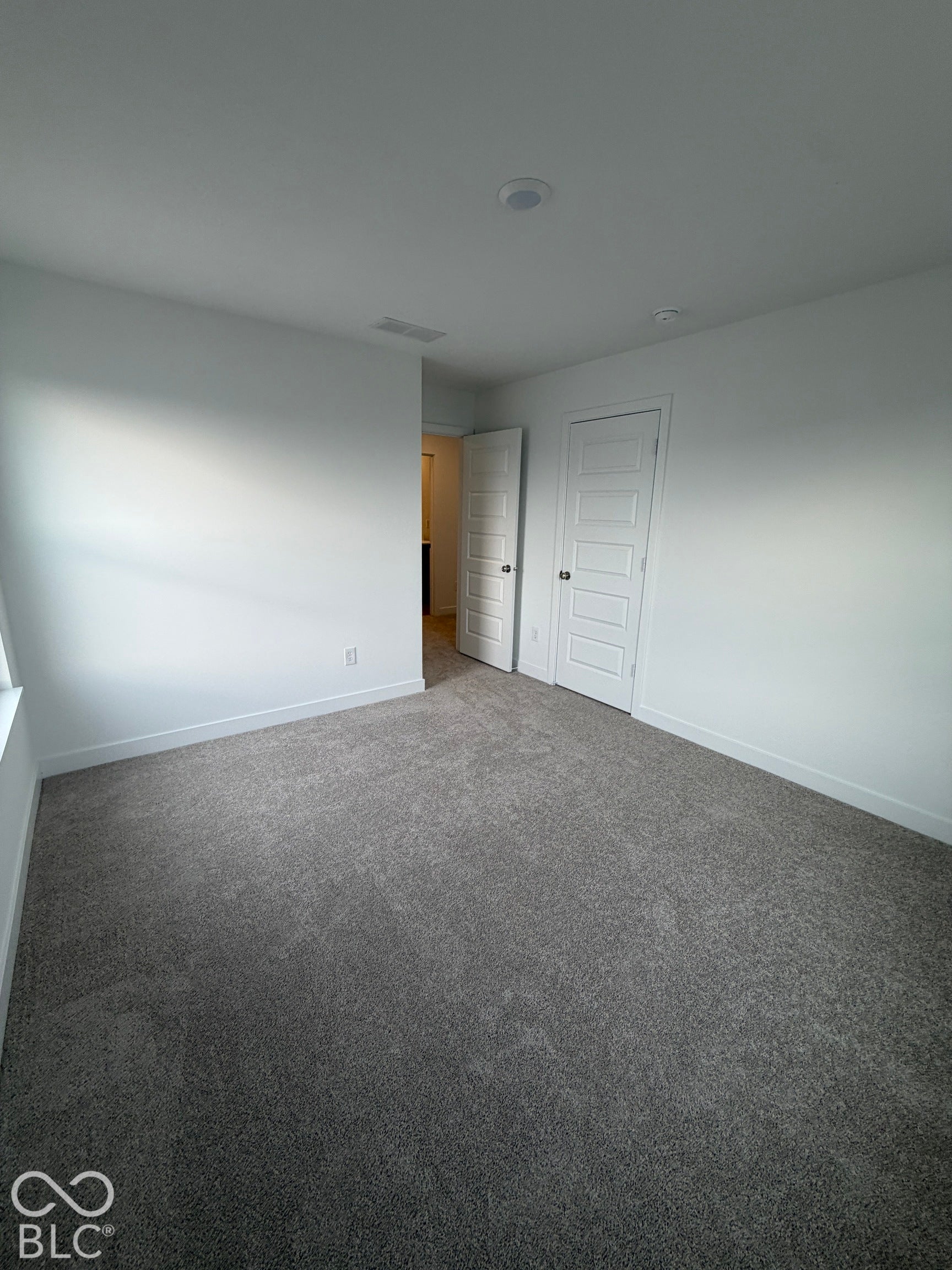 Neutral-toned wall-to-wall carpeting, five-panel interior doors, and recessed ceiling lighting