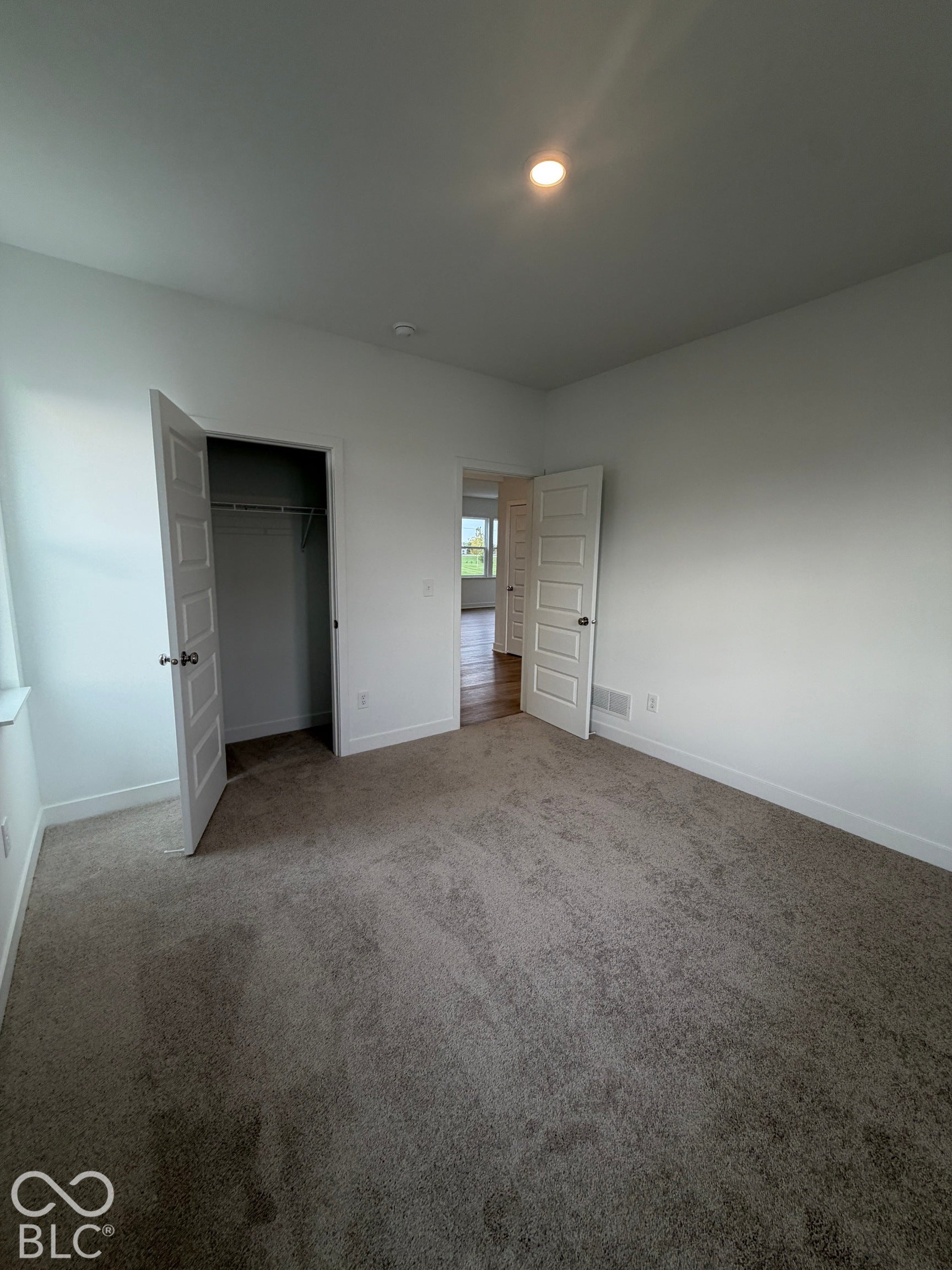 Room featuring neutral carpeting, five-panel interior doors, and recessed lighting
