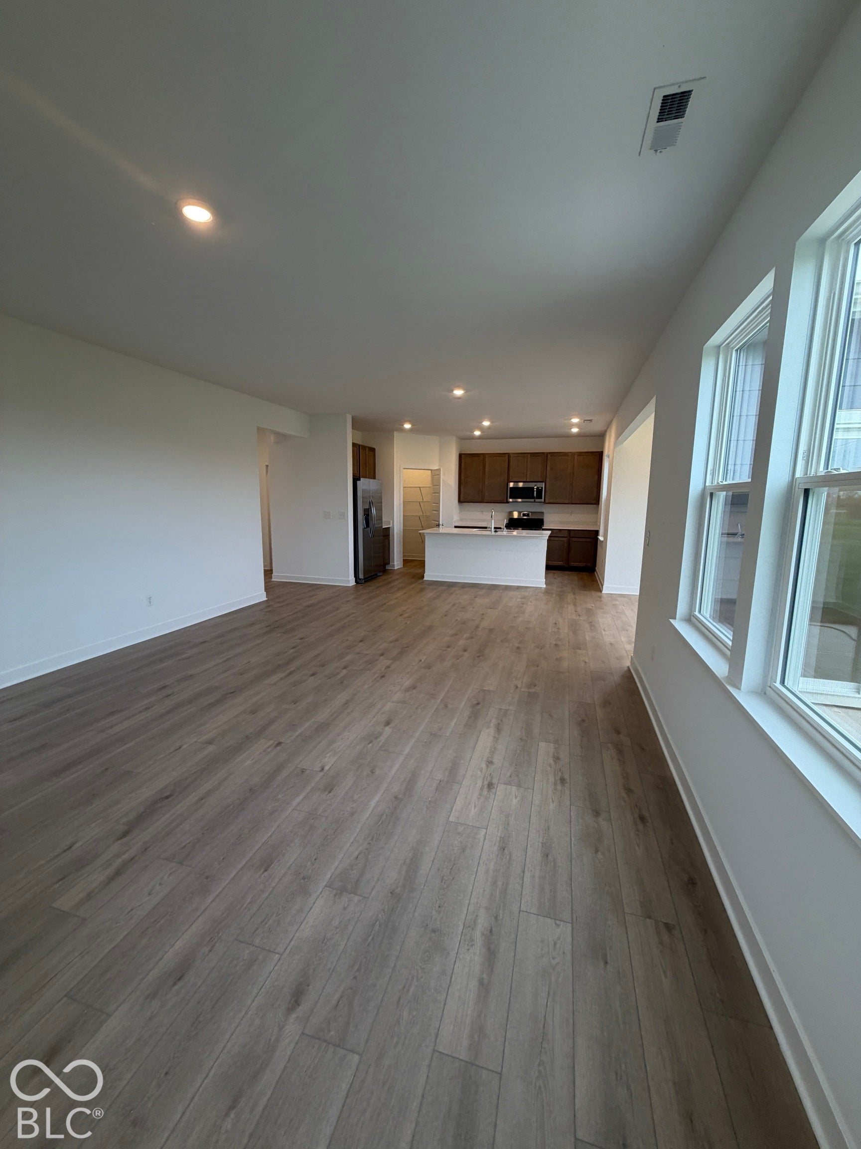 Open-concept floor plan featuring wood-finish flooring, recessed lighting, and large windows