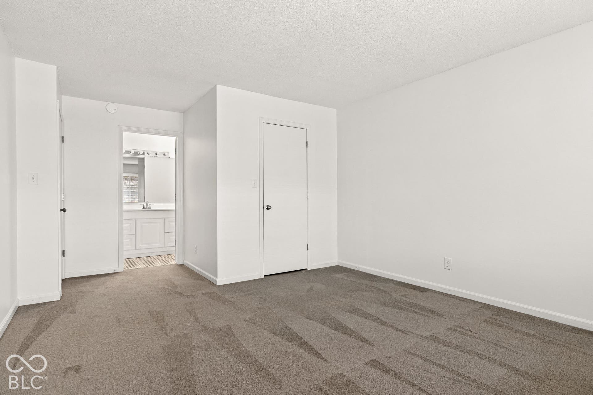 Interior room featuring neutral wall-to-wall carpeting and smooth white walls