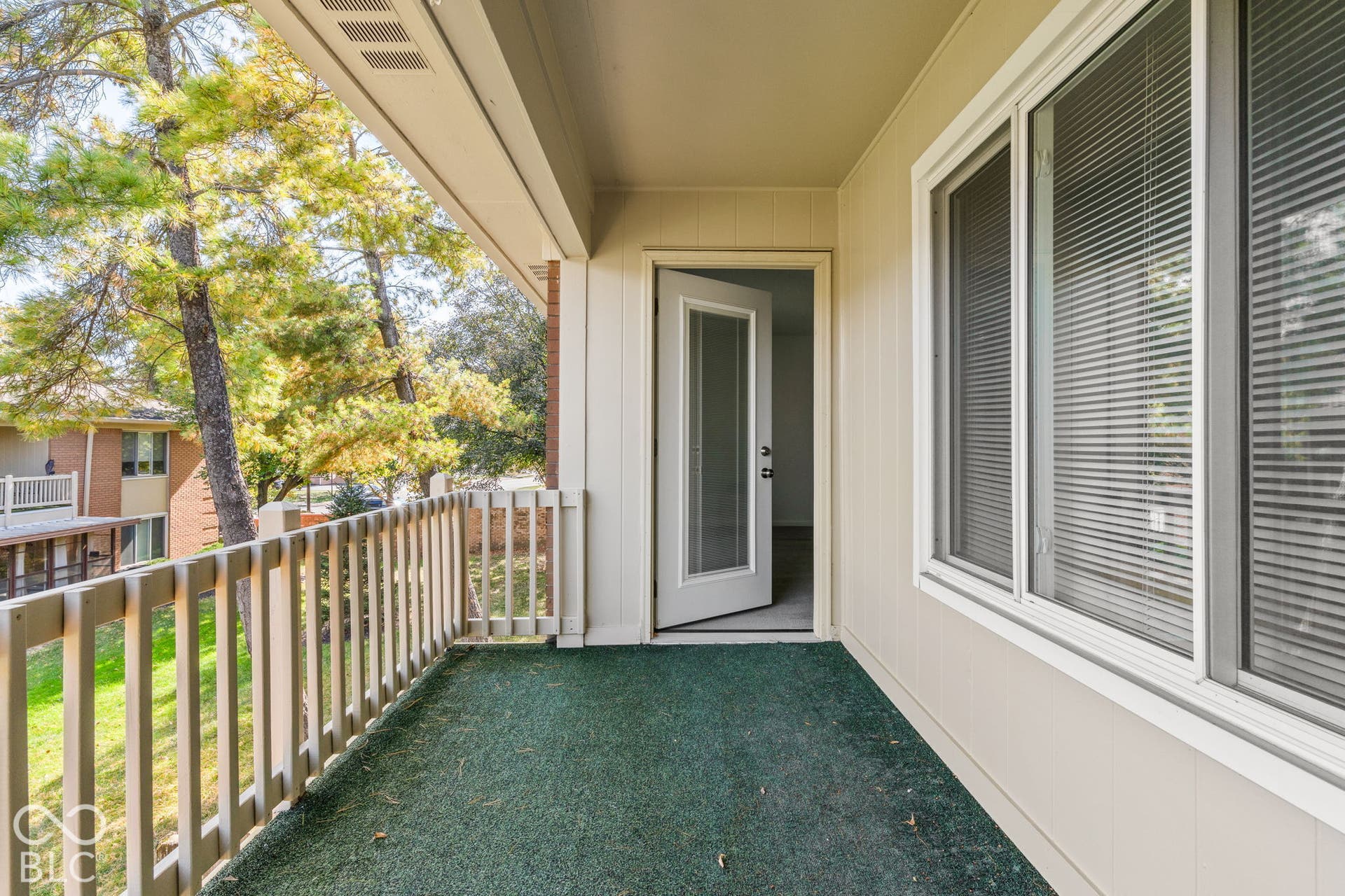 Covered balcony featuring wood-style railing and exterior access door
