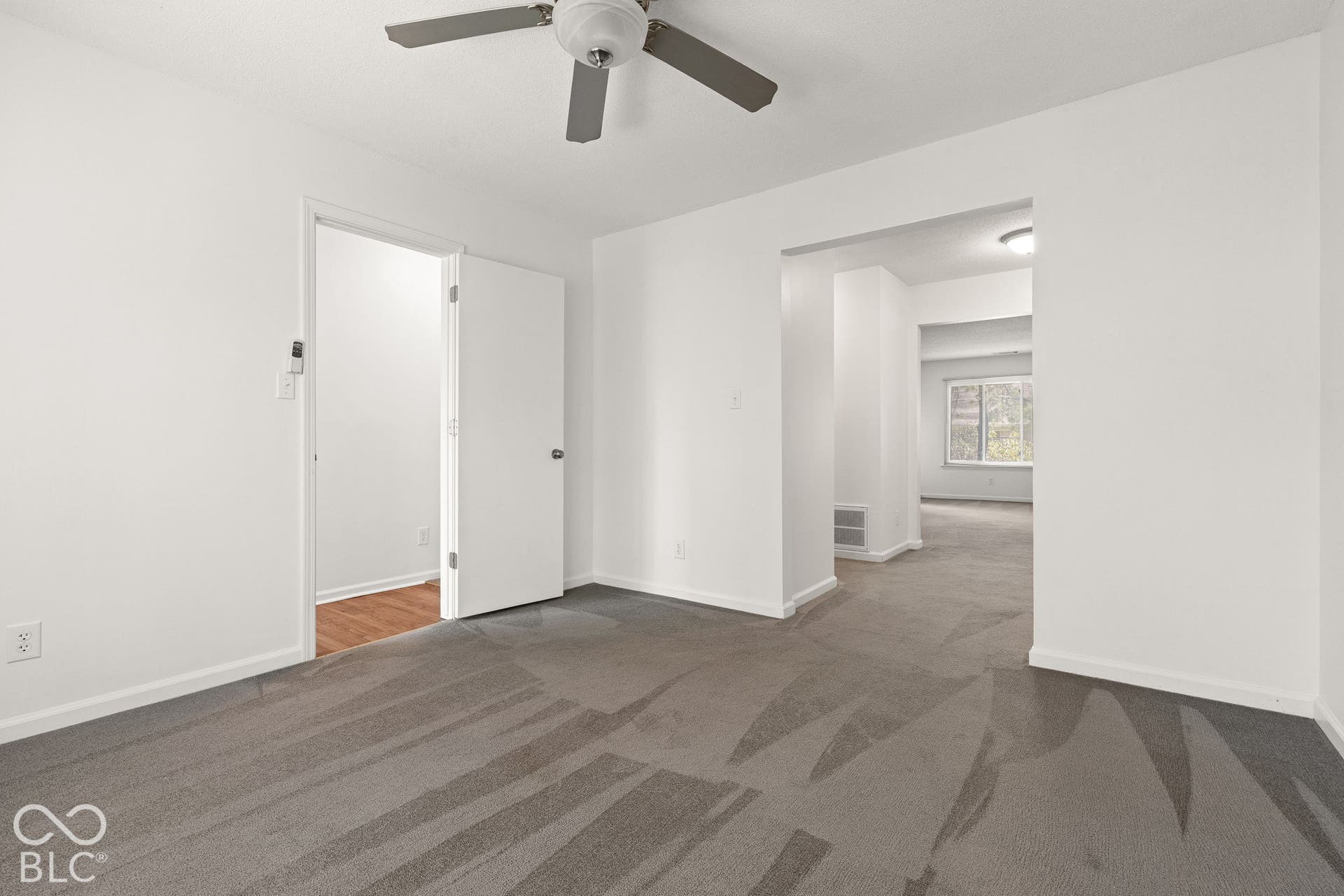 Room featuring wall-to-wall carpeting, ceiling-mounted paddle fan, and white interior doors