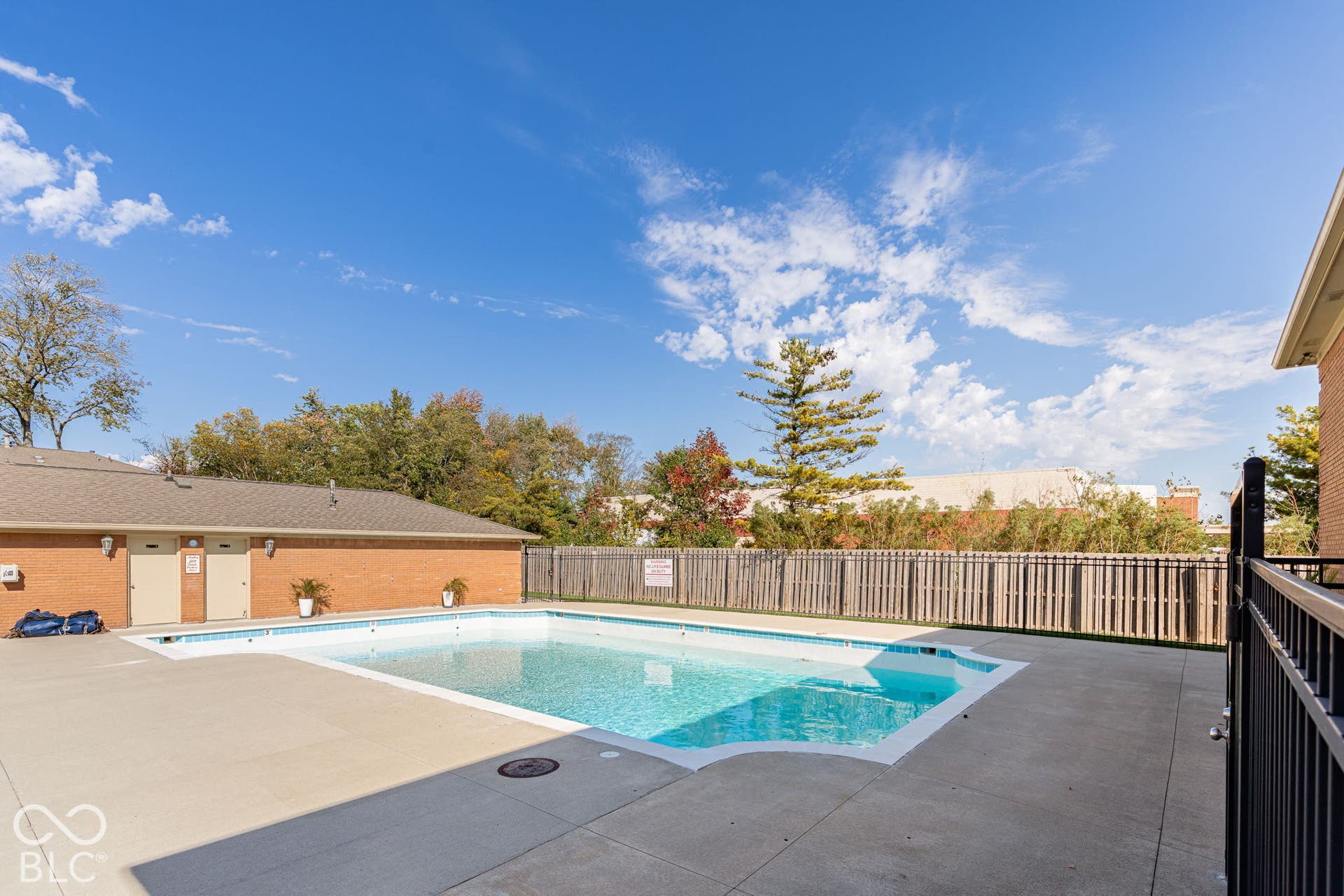 Outdoor swimming pool featuring a concrete deck and perimeter privacy fencing