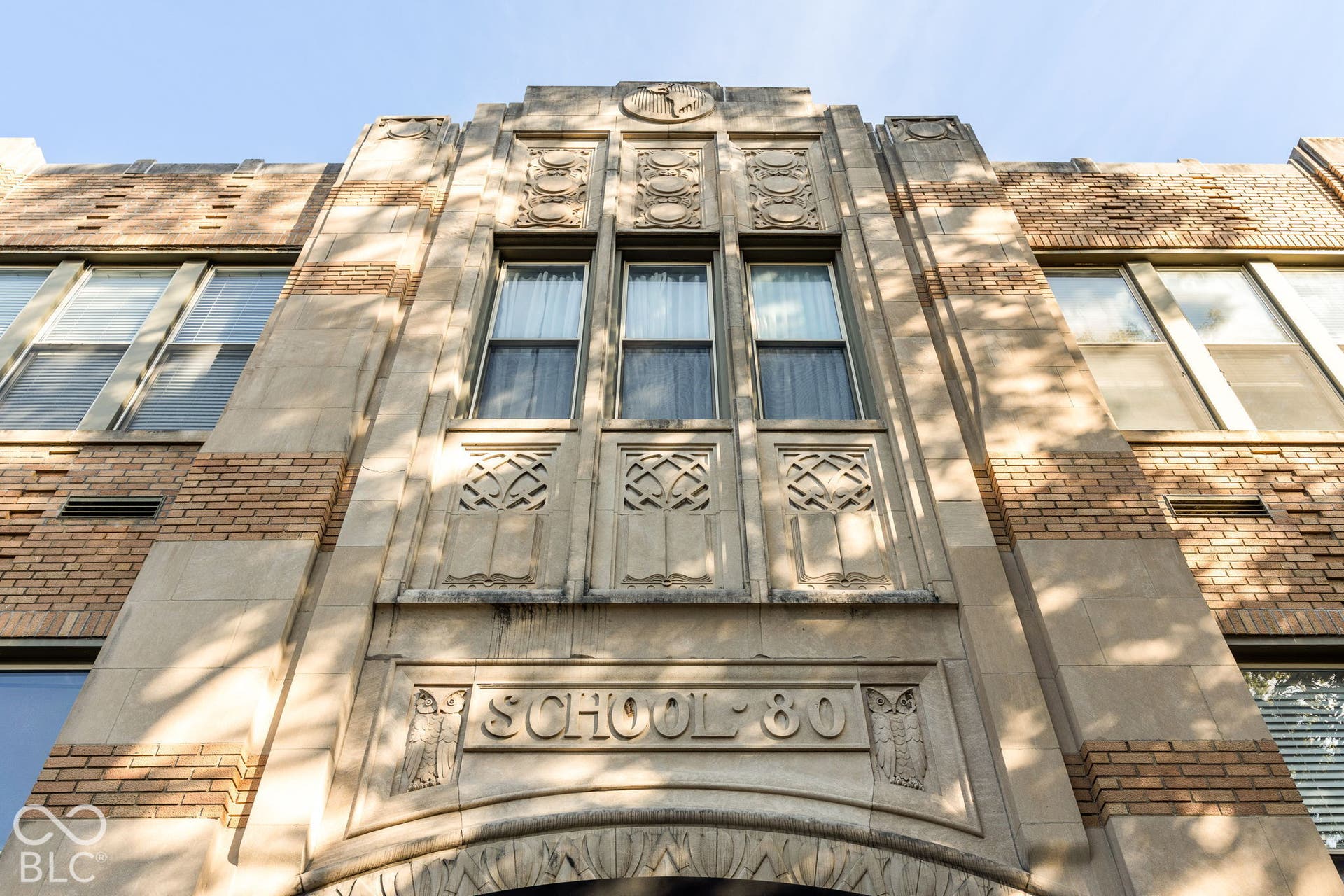 Art Deco exterior featuring masonry construction, intricate stone detailing, geometric relief carvings, and multi-pane windows