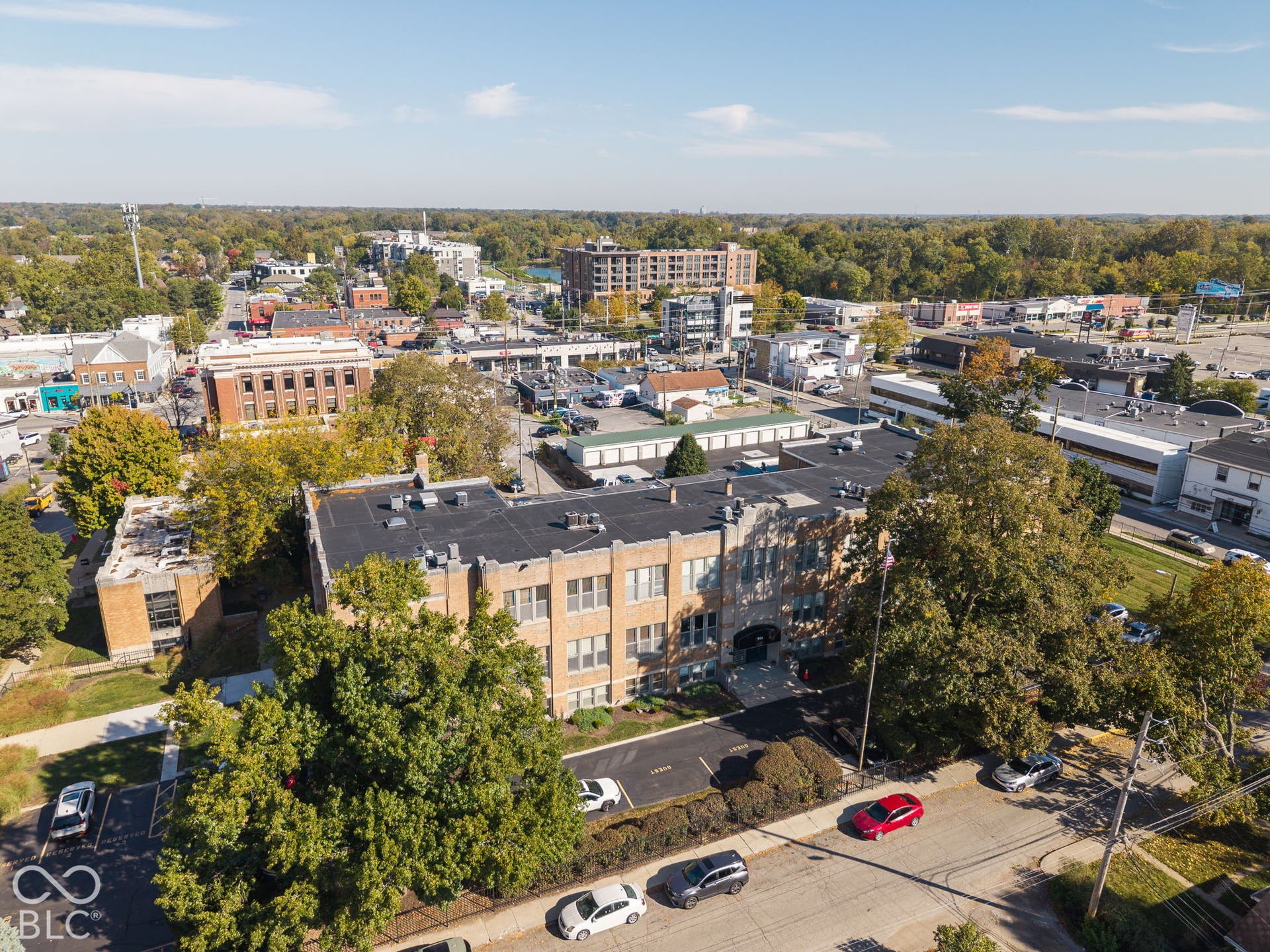Multi-story brick exterior featuring a flat roof and ground-level paved parking