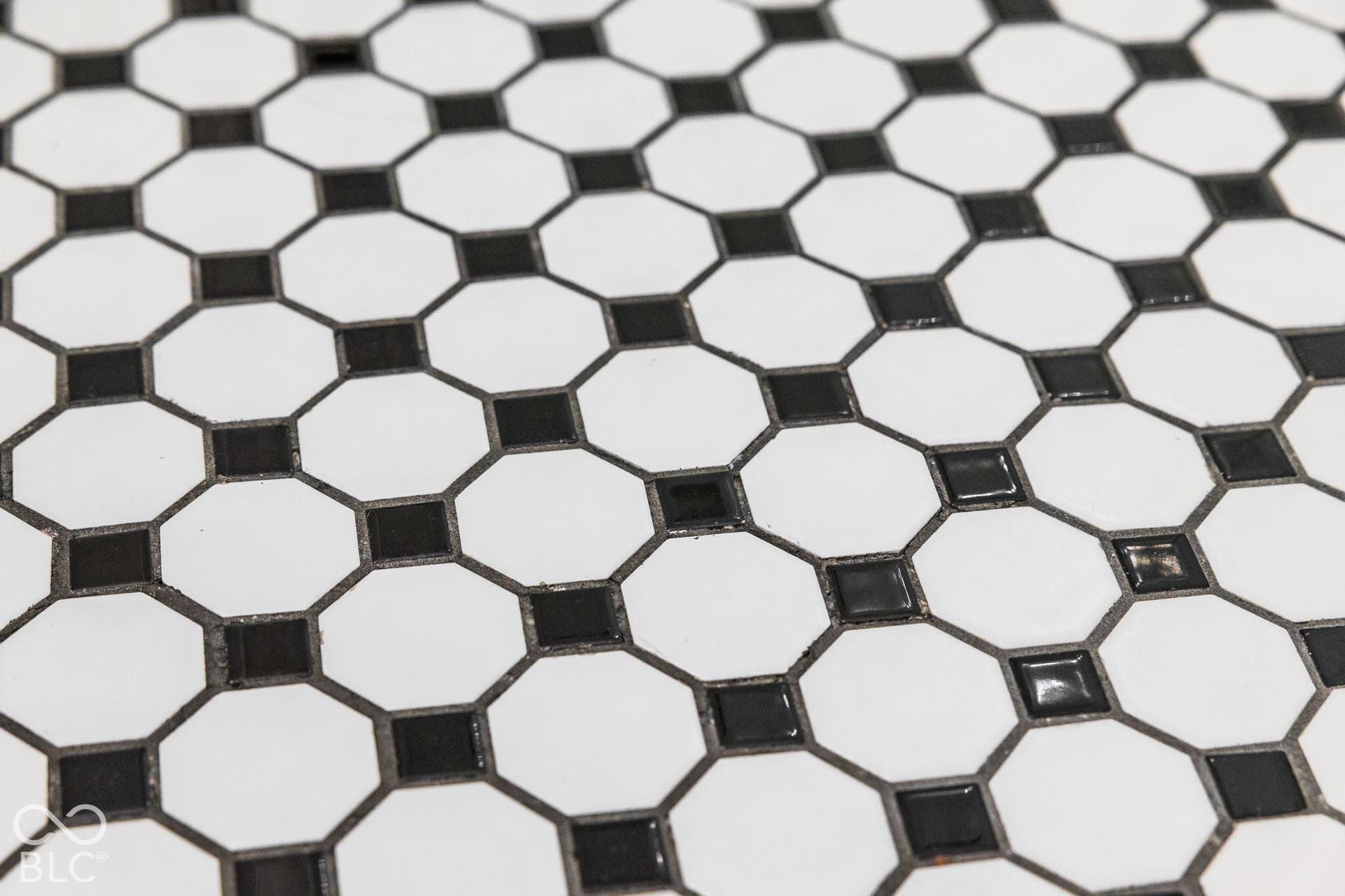 Classic monochromatic octagonal mosaic tile flooring featuring contrasting black accent squares