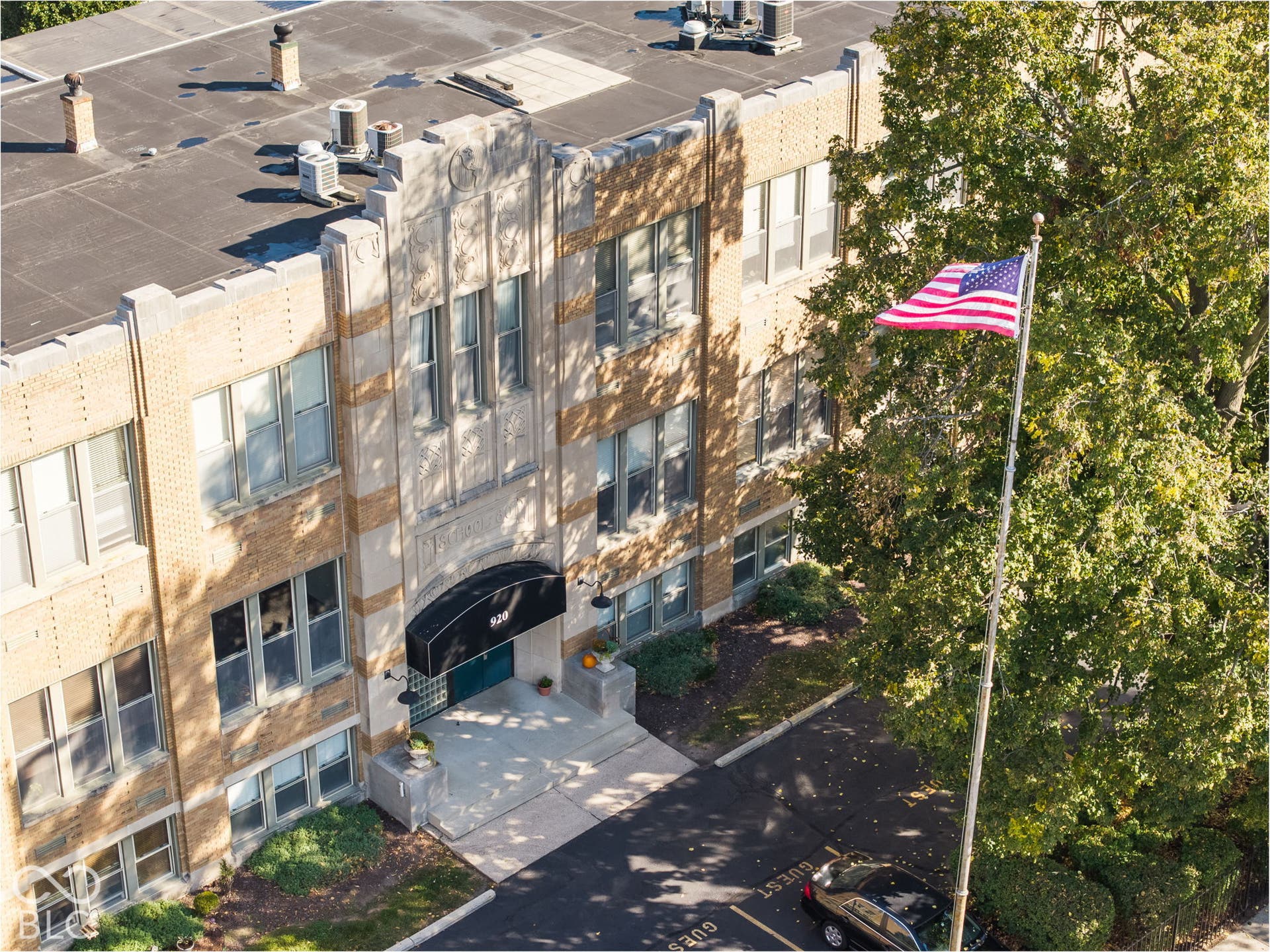 Multi-story brick exterior featuring decorative masonry detailing, arched entryway, and canopy awning