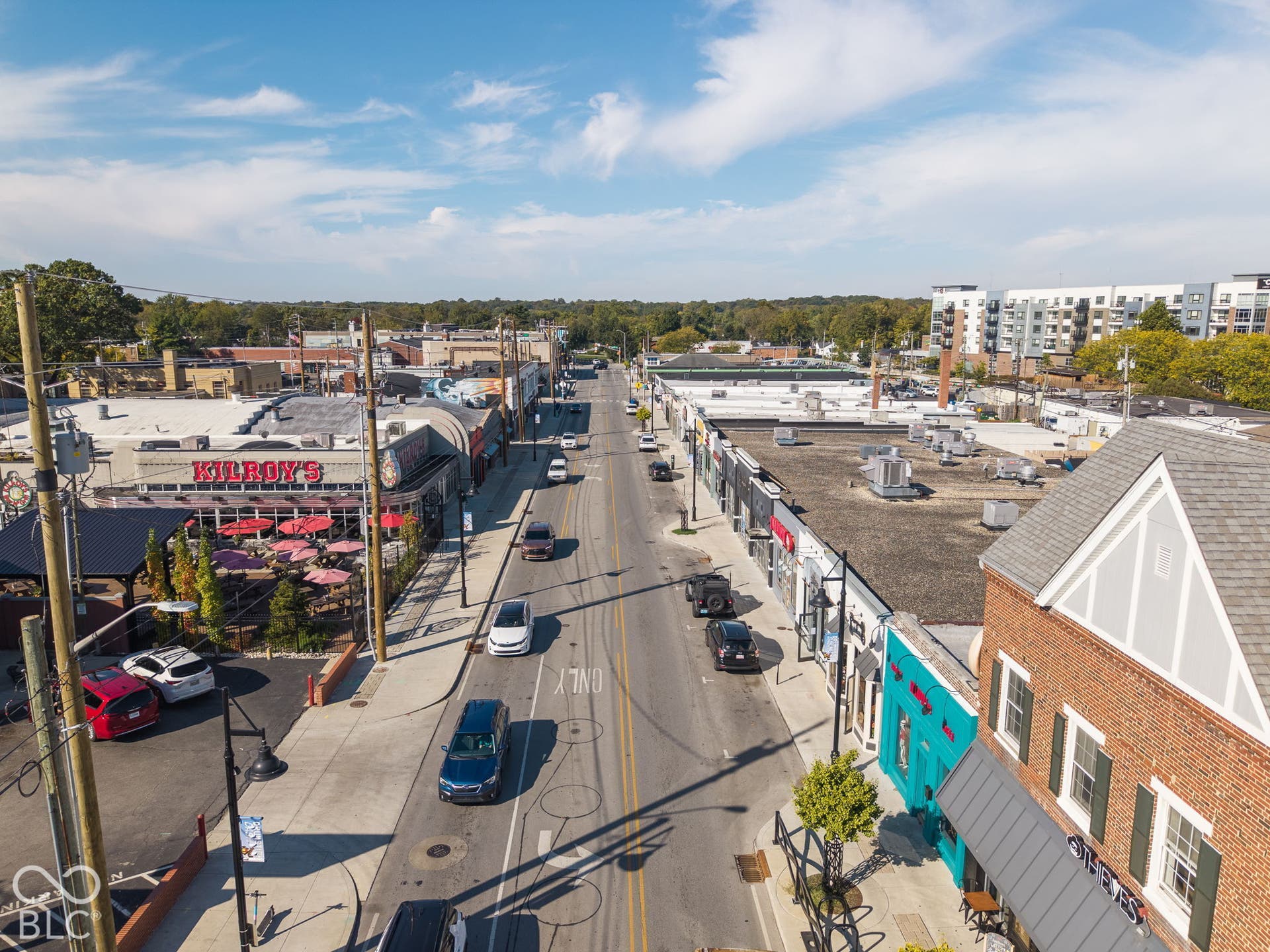 Aerial perspective of the commercial corridor featuring multi-story brick facades, metal roofing elements, and street-level storefronts