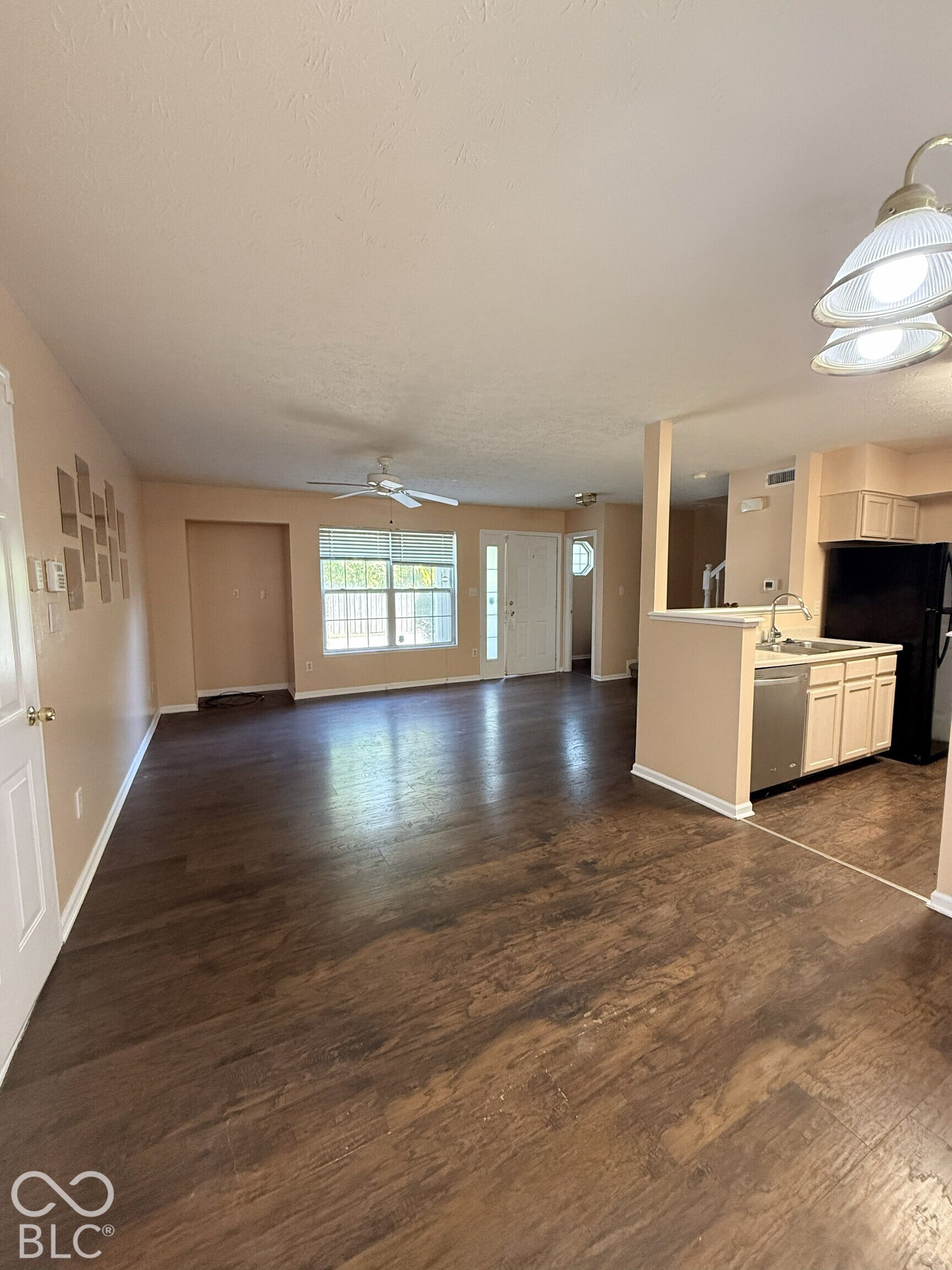 Interior space featuring wood-finish flooring, recessed lighting, ceiling fan, and a kitchen equipped with cabinetry and stainless steel appliances