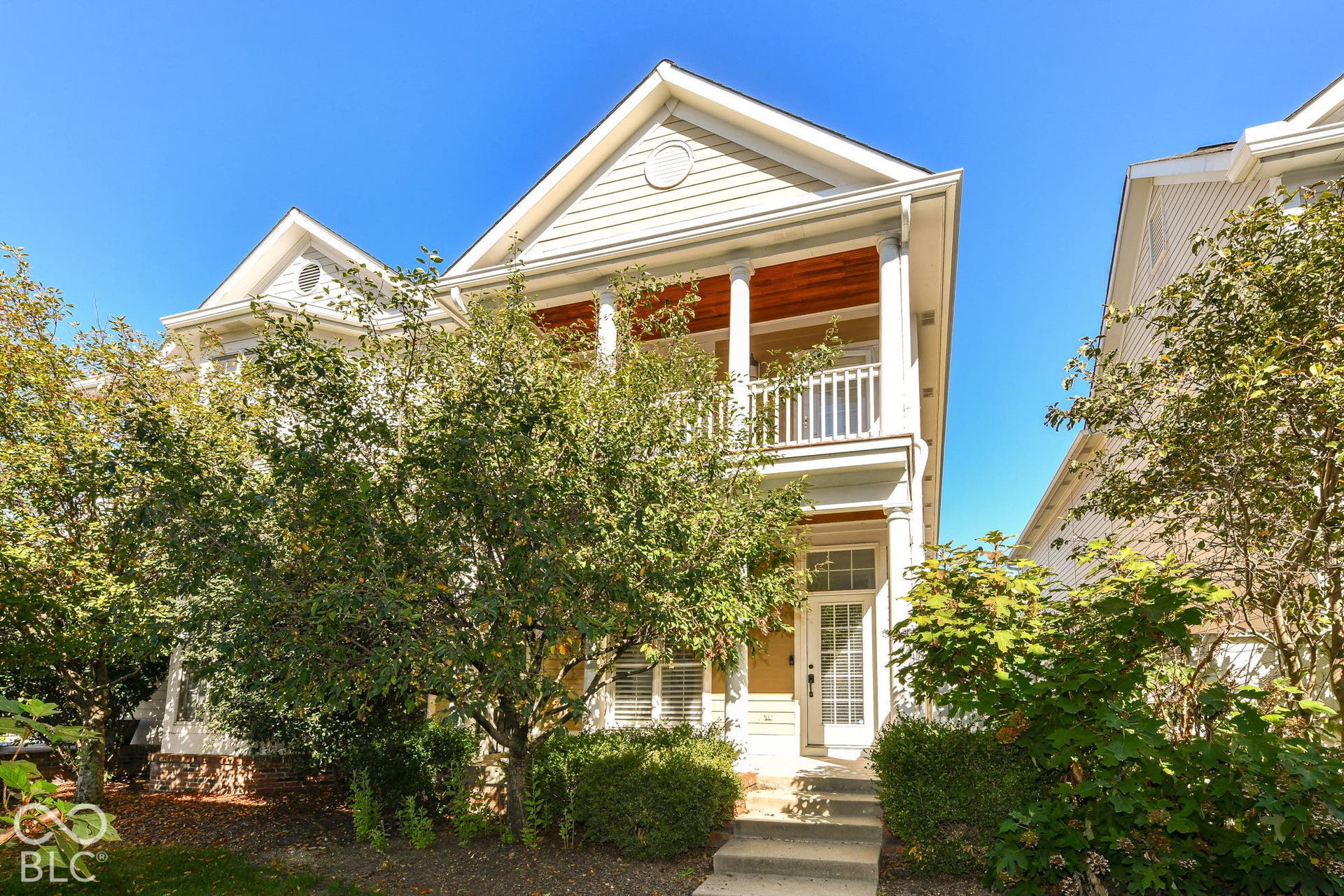Two-story exterior featuring a covered upper-level balcony with a wood-finished ceiling