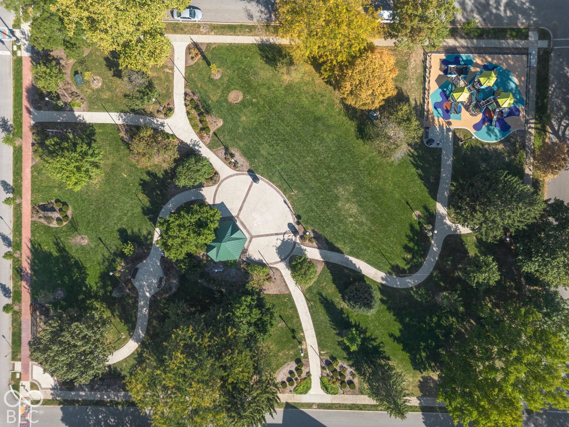Aerial view of Seminary Park featuring mature trees, sidewalks, circular plaza, a covered gazebo, and playground.