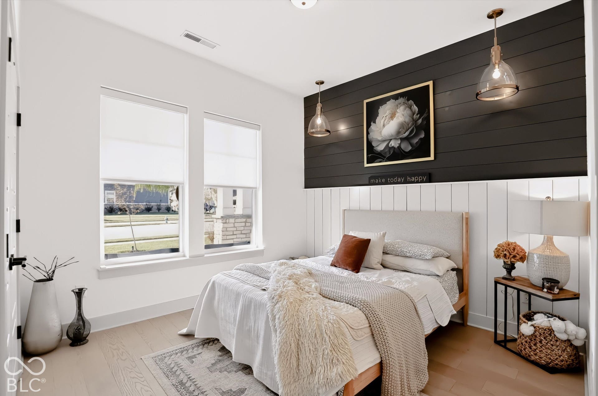 Wood-finish flooring, high ceilings, dual-tone horizontal wall paneling, and dual pendant lighting fixtures