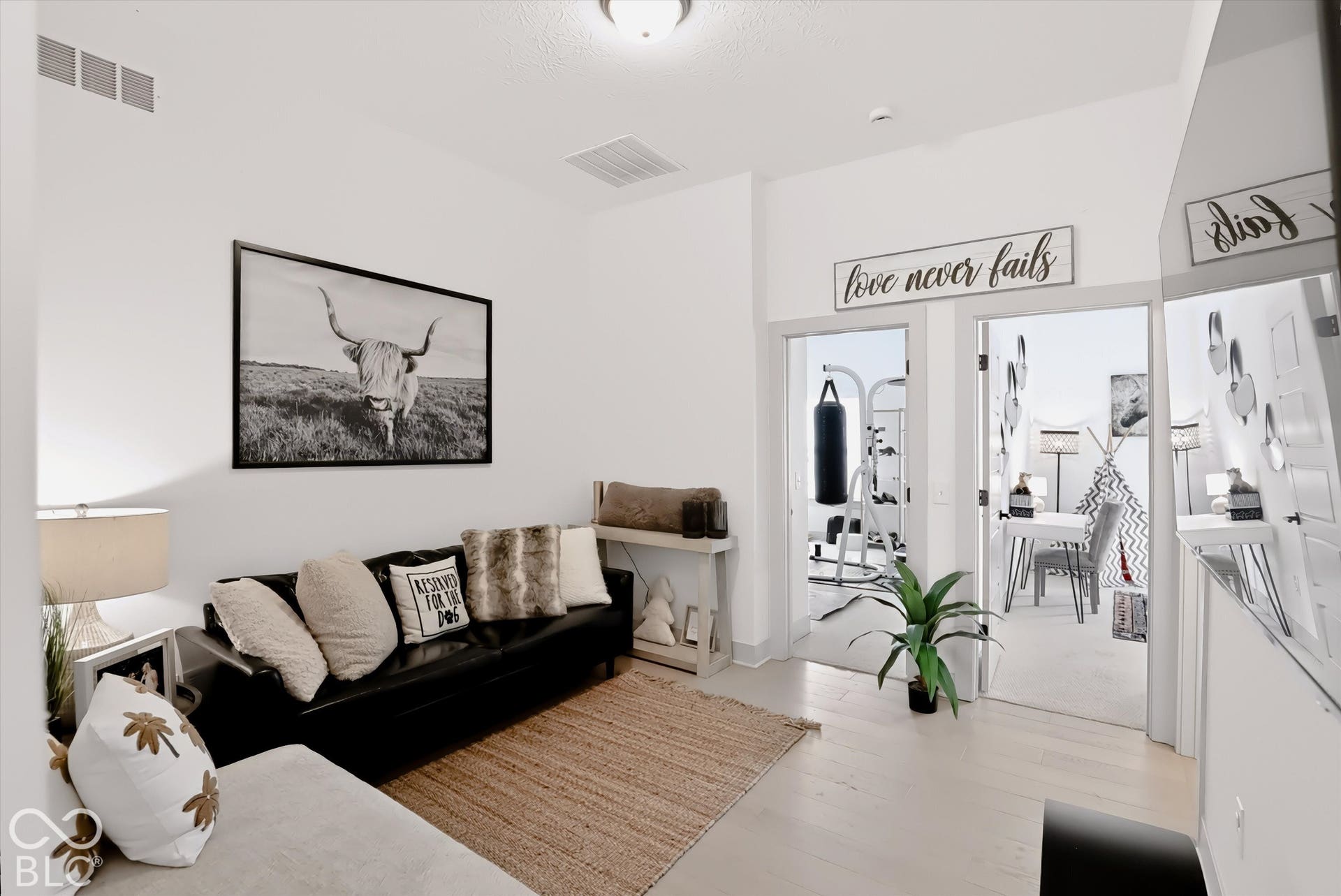 Interior space featuring neutral wall paint, wood-finish flooring, two doorways, and a ceiling-mounted light fixture