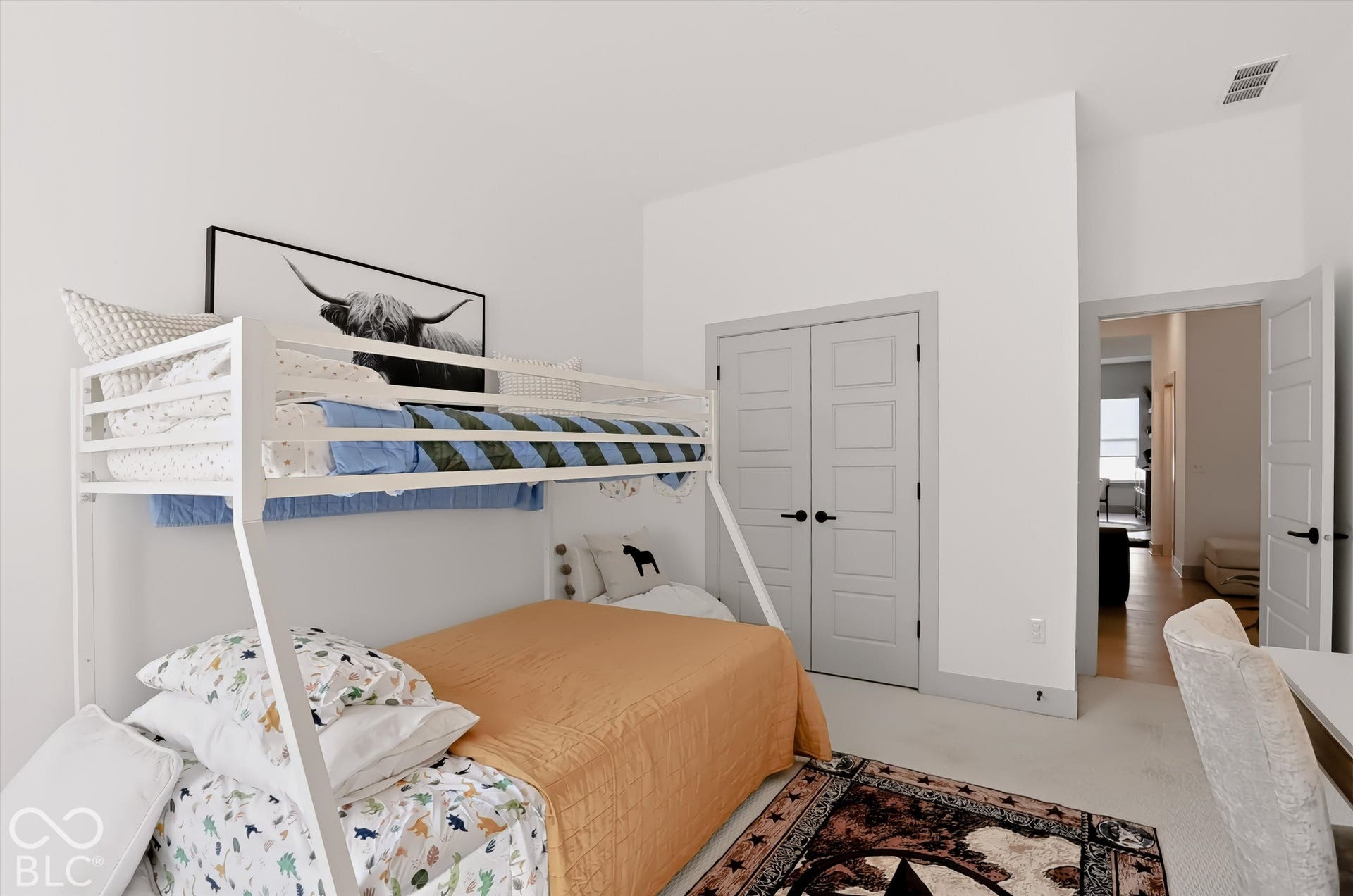 Neutral interior space featuring high ceilings, carpeted flooring, and double-panel doors with matte black hardware