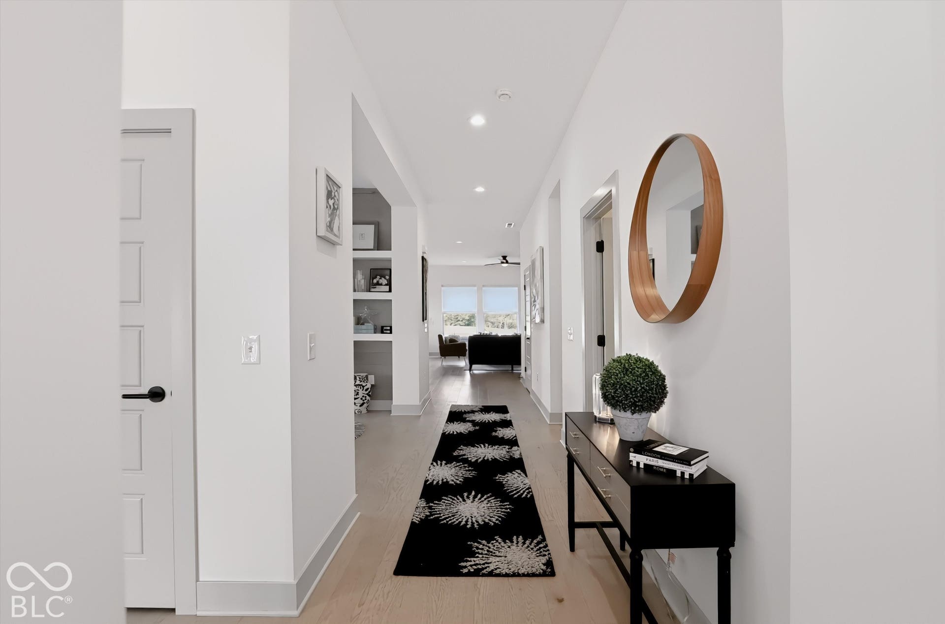 Interior hallway featuring light wood-finish flooring, recessed lighting, and built-in recessed shelving