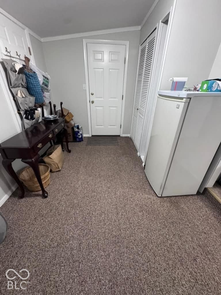 906 S Patterson, Lebanon, IN 46052 Neutral wall color, carpeted flooring, white four-panel entry door, and white louvered-style bi-fold closet doors