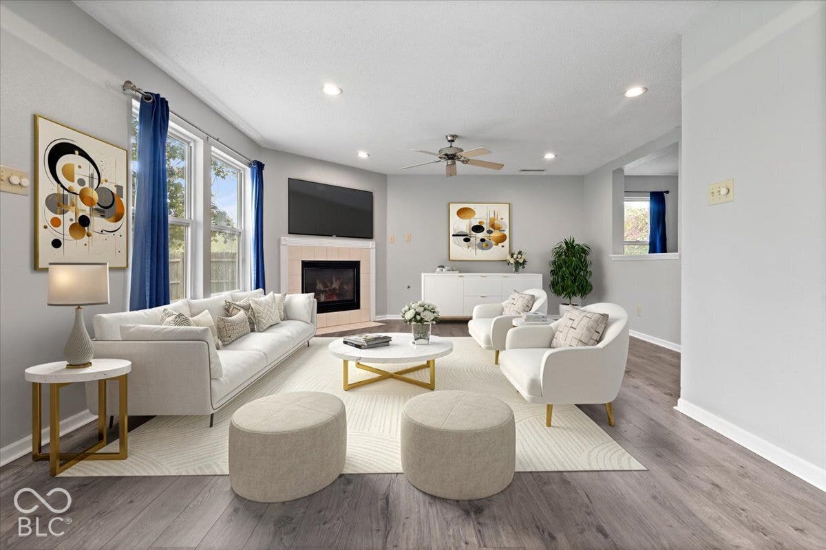 Virtually Altered - Living area featuring wood-finish flooring, recessed lighting, ceiling fan, and a fireplace with tile surround