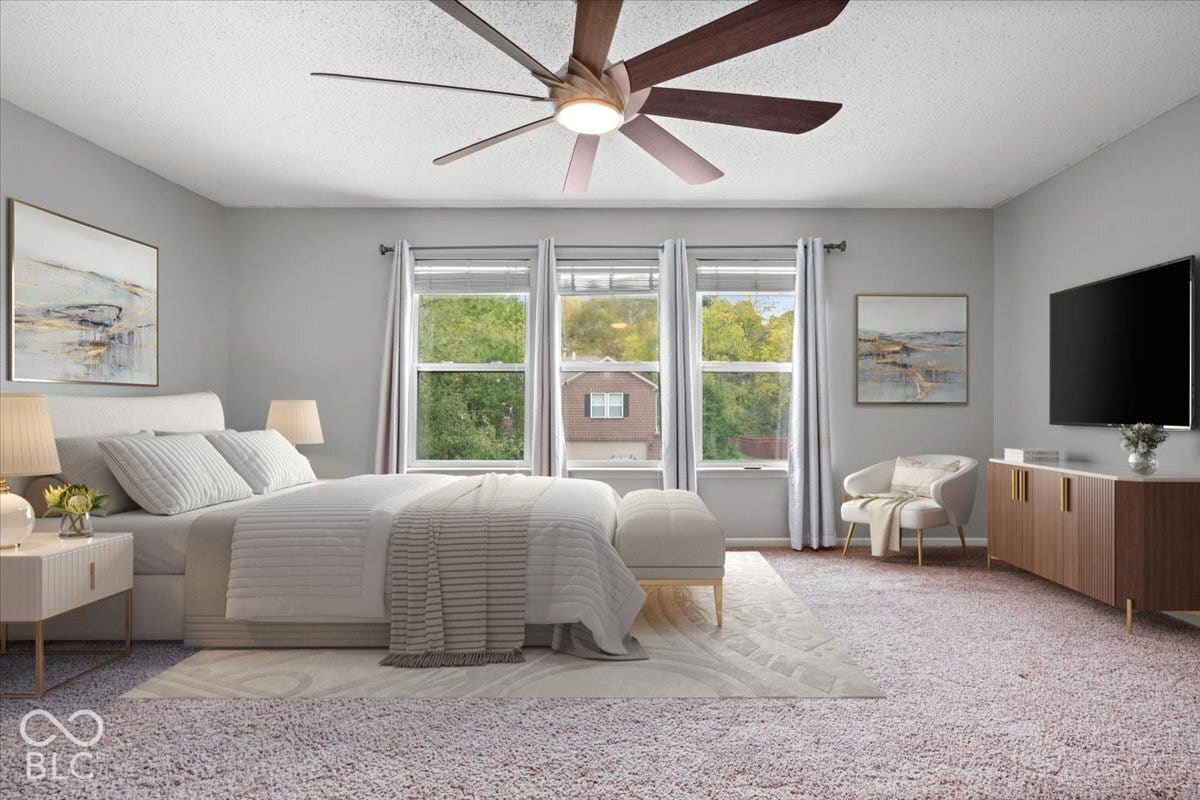 Spacious room featuring a multi-blade ceiling fan with integrated lighting and three large windows