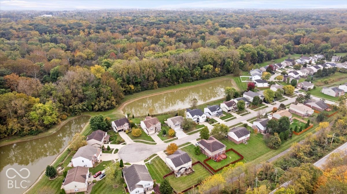 Aerial perspective of the residential community featuring ponds, abundant mature trees, and a cul-de-sac layout